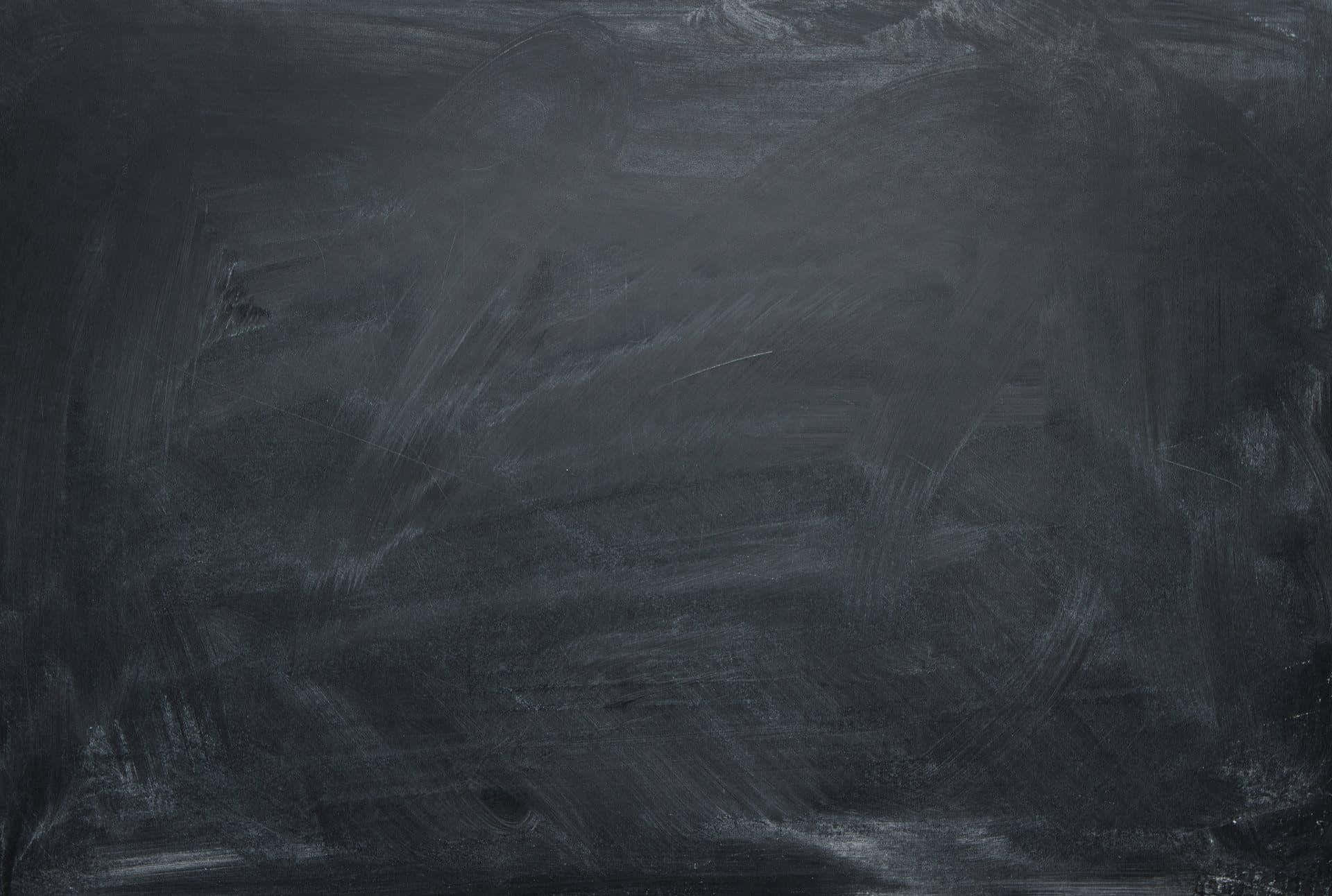 Blackboard 桌布 壁紙 — 深灰色黑板表面的特寫，可見粉筆污跡和擦除的書寫痕跡。