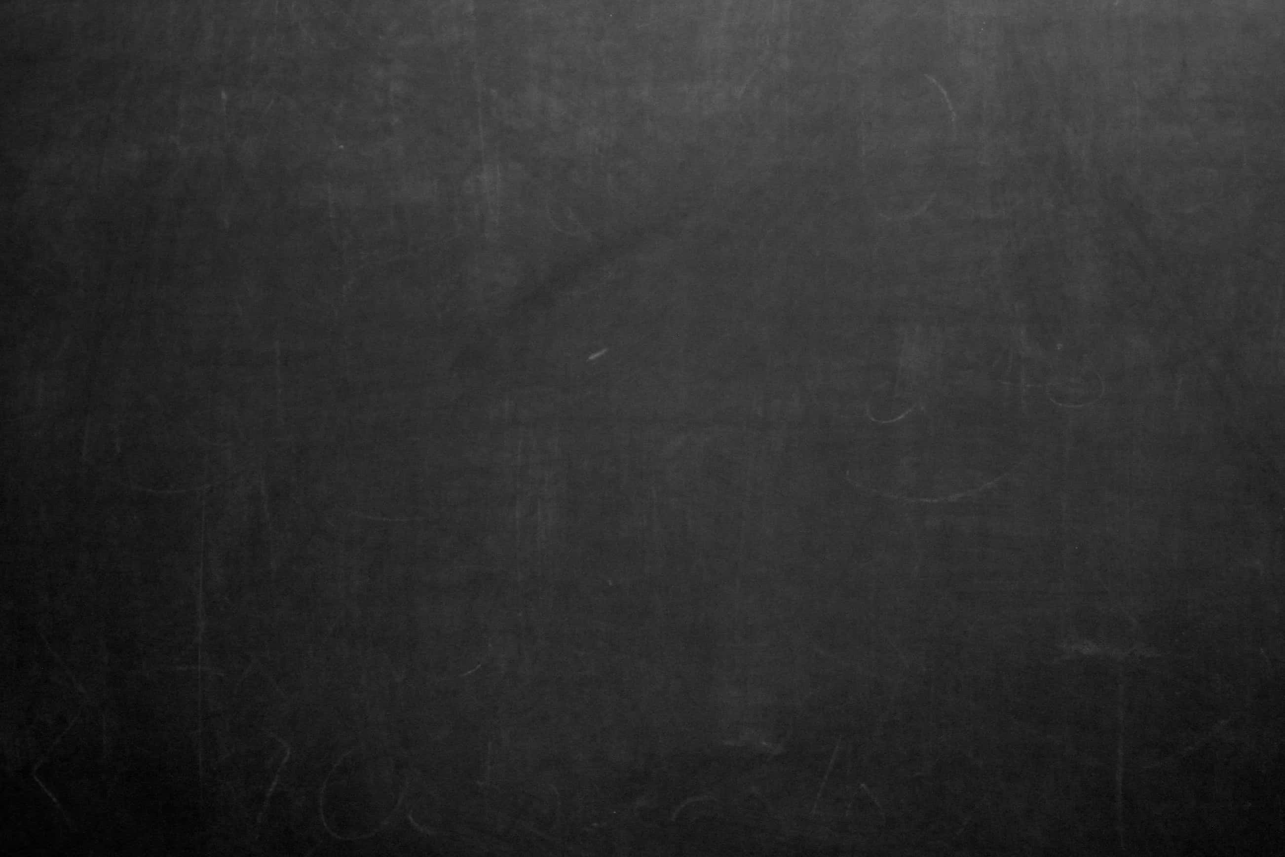Chalkboard 桌布 壁紙 — 深灰色黑板表面的特寫，帶有模糊的擦除粉筆痕跡和細微紋理。
