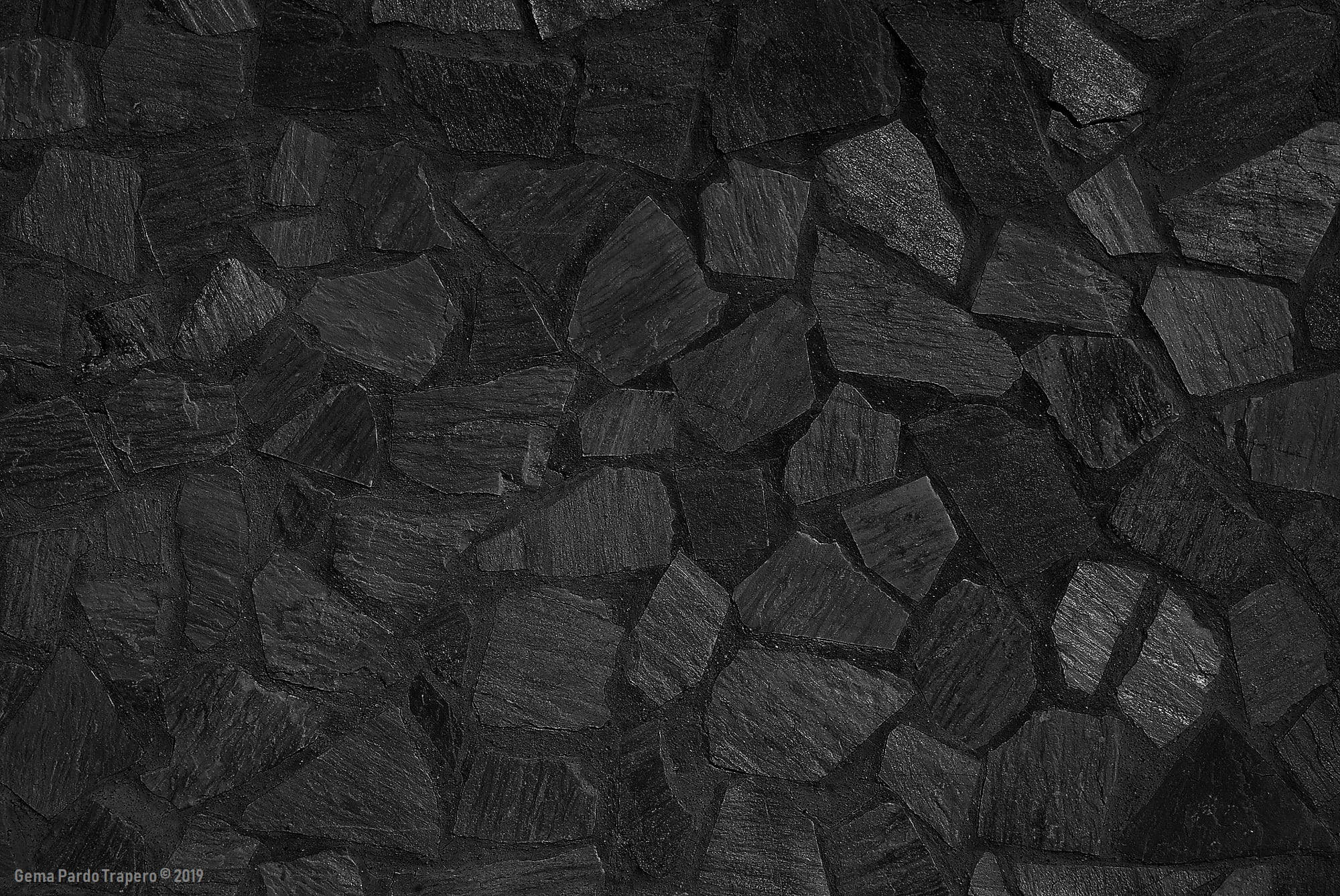 Stone Wall 桌布 壁紙 — 深炭黑色板岩的近距離特寫，表面粗糙有紋理，帶有微妙的灰色亮點。