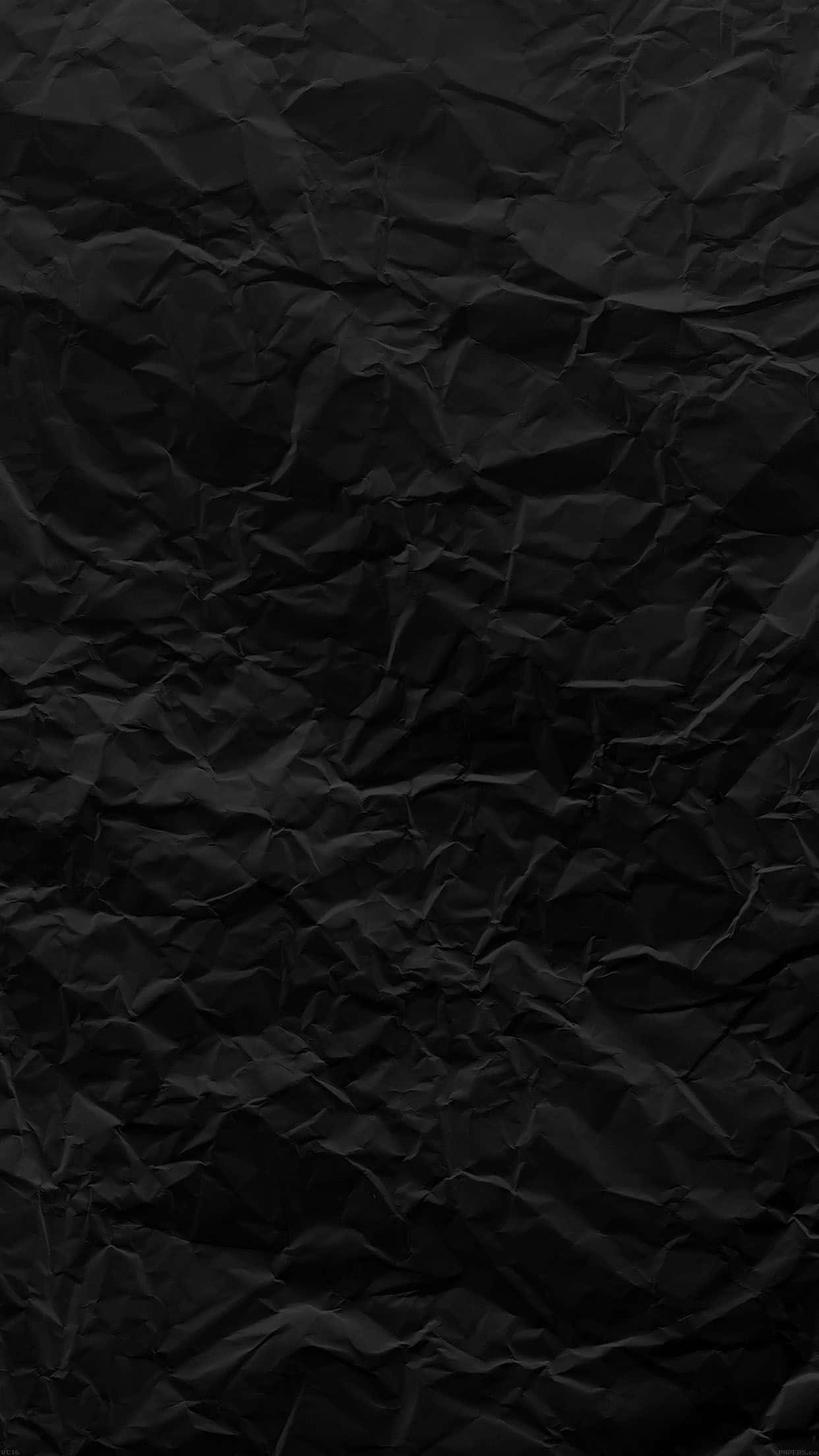 Dark Textured 桌布 壁紙 — 深皺黑色紙張的特寫，微妙的陰影突顯其紋理褶皺。