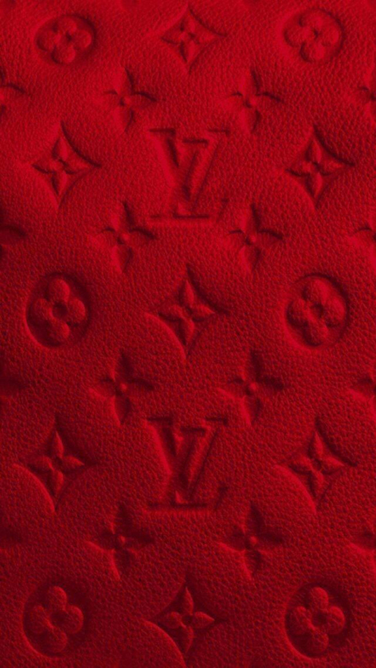Red Baddie 桌布 壁紙 — 深紅色帶有壓花Louis Vuitton字母組合圖案的豐富紅色紋理布料。