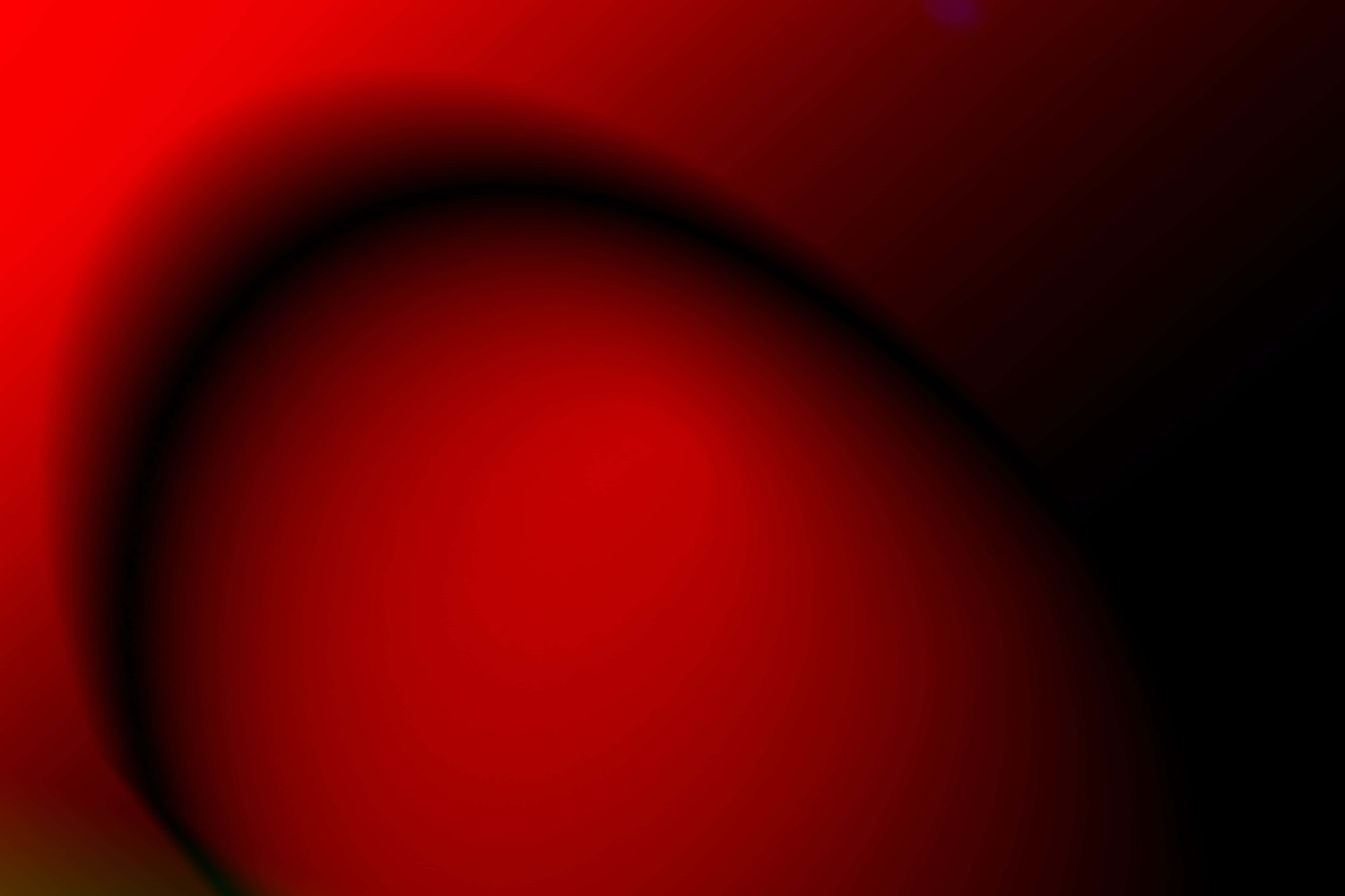 Red Color 桌布 壁紙 — 深紅色抽象漩渦逐漸淡入黑色，帶有柔和漸變和微妙的鏡頭光暈點綴。