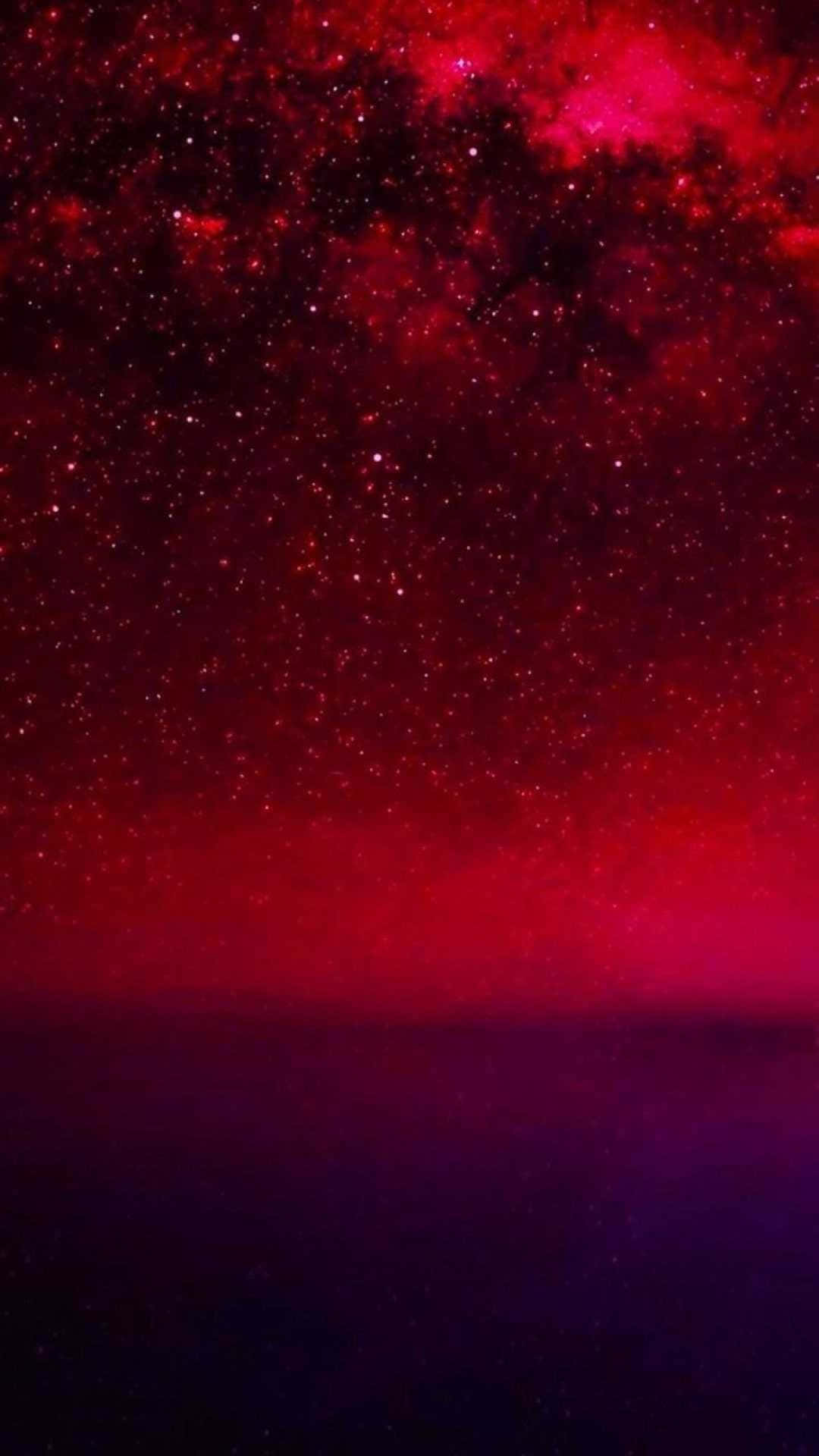 Pastel Red Aesthetic 桌布 壁紙 — 深紅色星雲和閃爍恆星的宇宙廣闊空間，在深紫色地平線上方延伸。