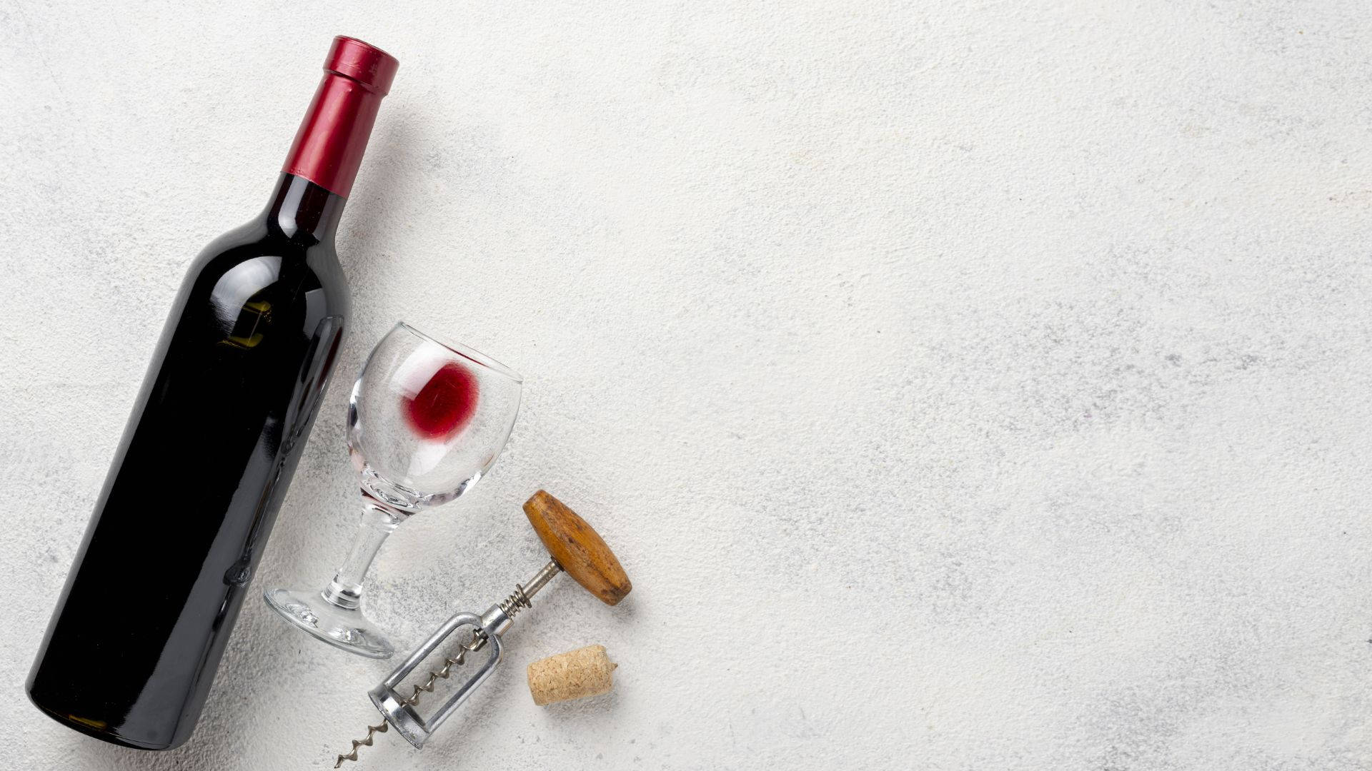 Drink 桌布 壁紙 — 深紅色酒瓶、玻璃杯、開瓶器和軟木塞放在有紋理的白色表面上。