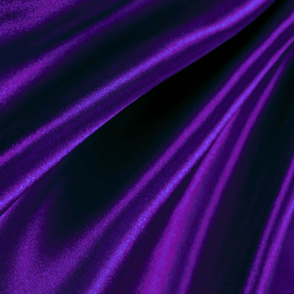 Purple Satin 桌布 壁紙 — 深紫色天鵝絨布料，帶有深邃褶皺，在深色背景上閃爍著光澤。