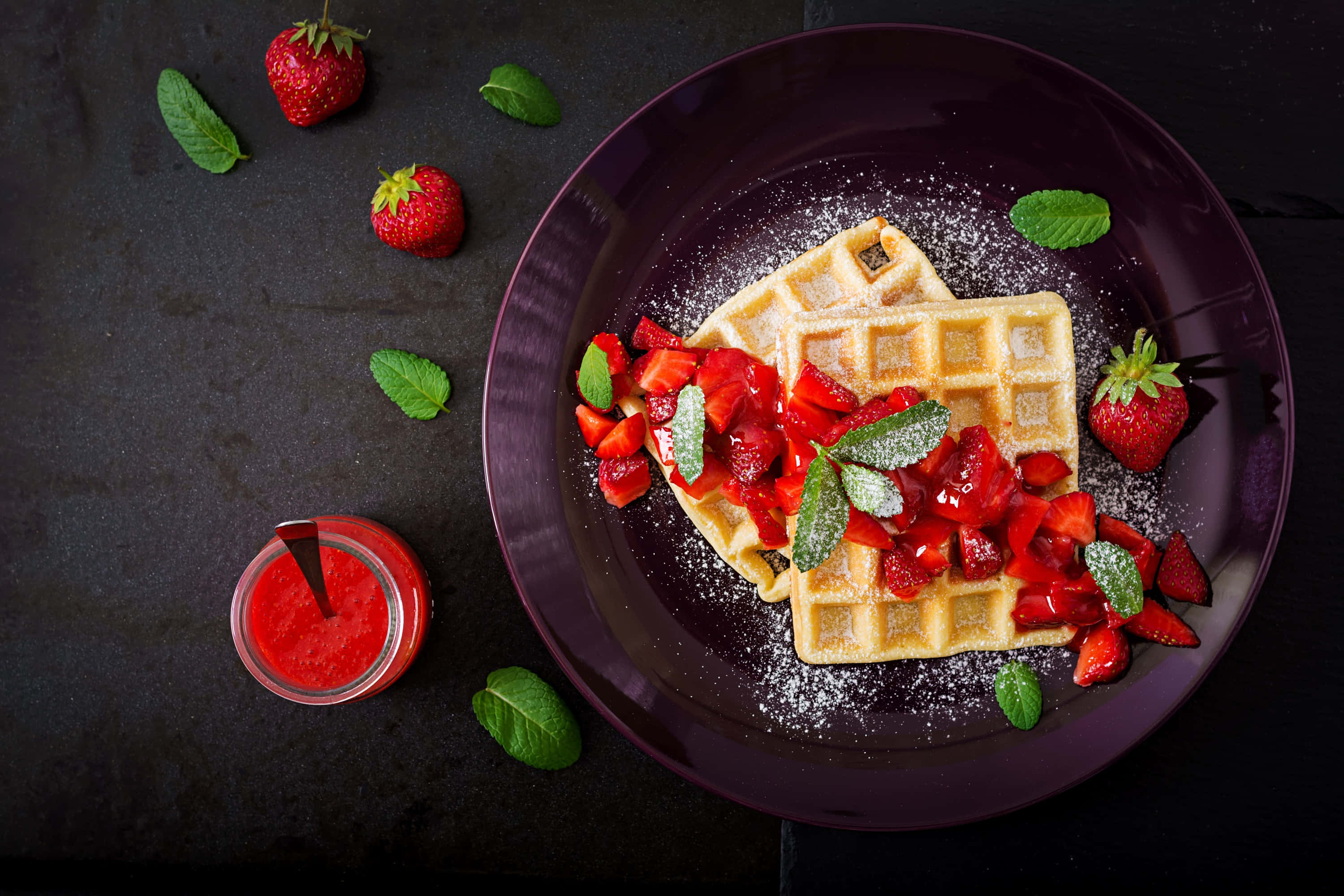 Waffle 桌布 壁紙 — 深紫色盤子上放有金黃色鬆餅，配上新鮮草莓、薄荷和糖粉。