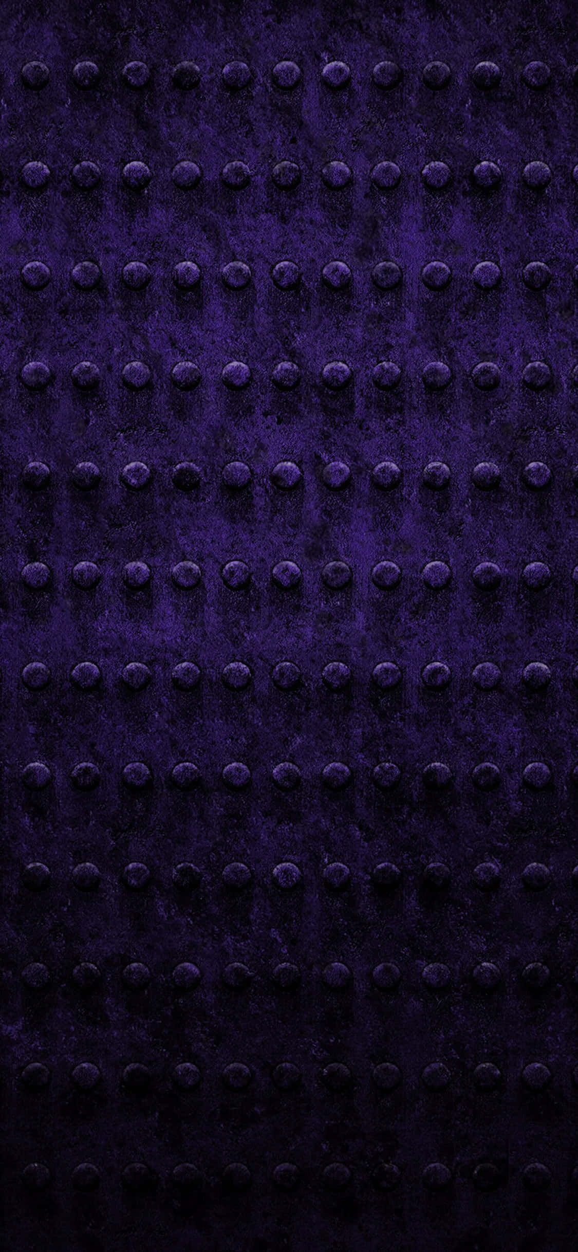 Purple Texture 桌布 壁紙 — 深紫色紋理表面的特寫，均勻分佈的凸起鉚釘形成重複的工業圖案。