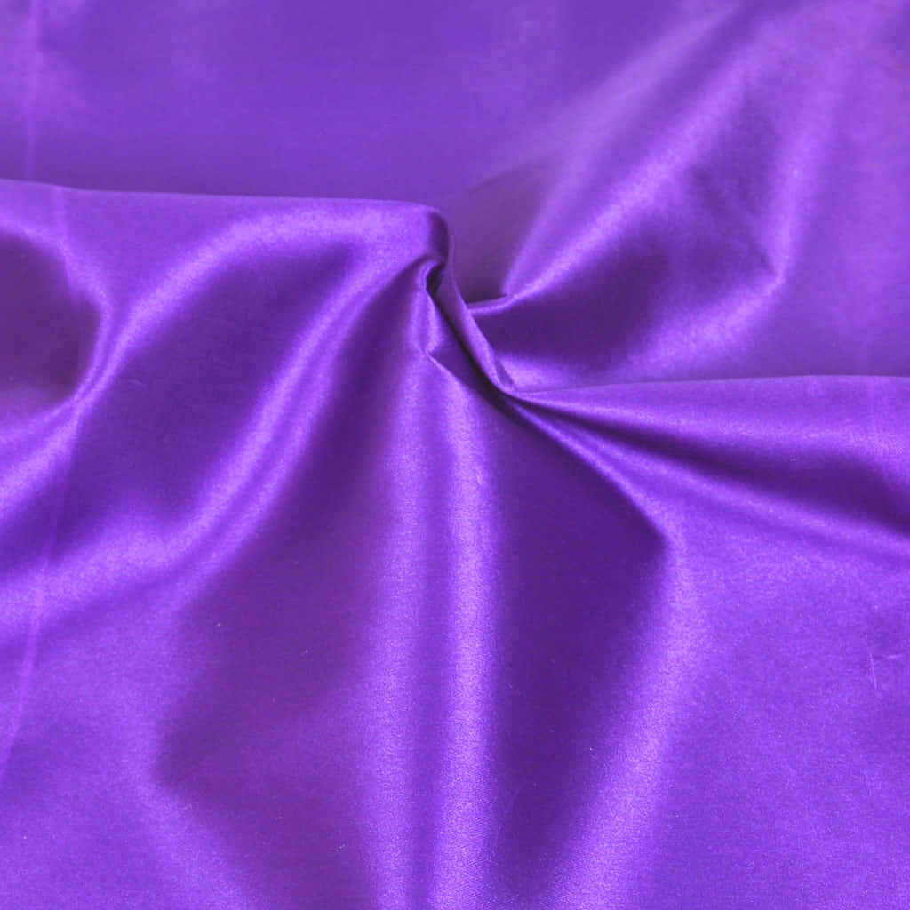 Purple Satin 桌布 壁紙 — 深紫色緞面布料，帶有光澤褶皺，在特寫紋理拍攝中捕捉柔和光線。