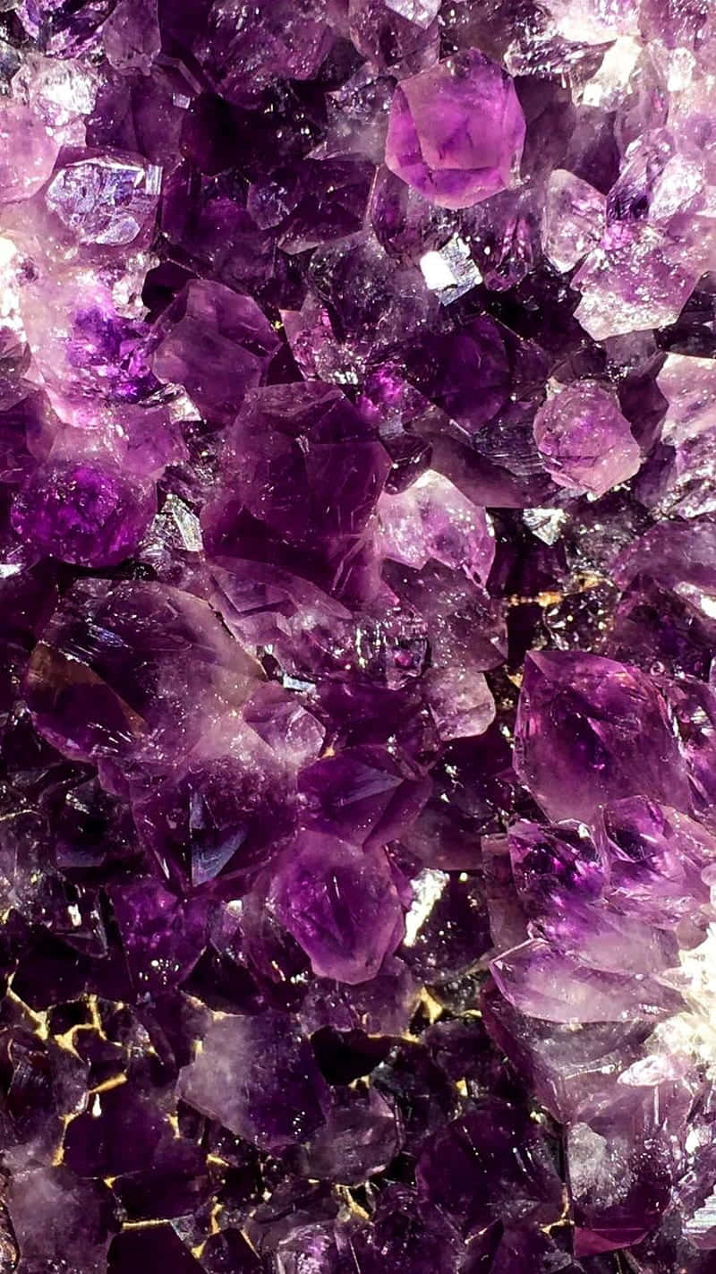 水晶 桌布 壁紙 — 深紫色閃爍紫水晶晶體的近距離特寫，金色紋理透過半透明切面閃耀。