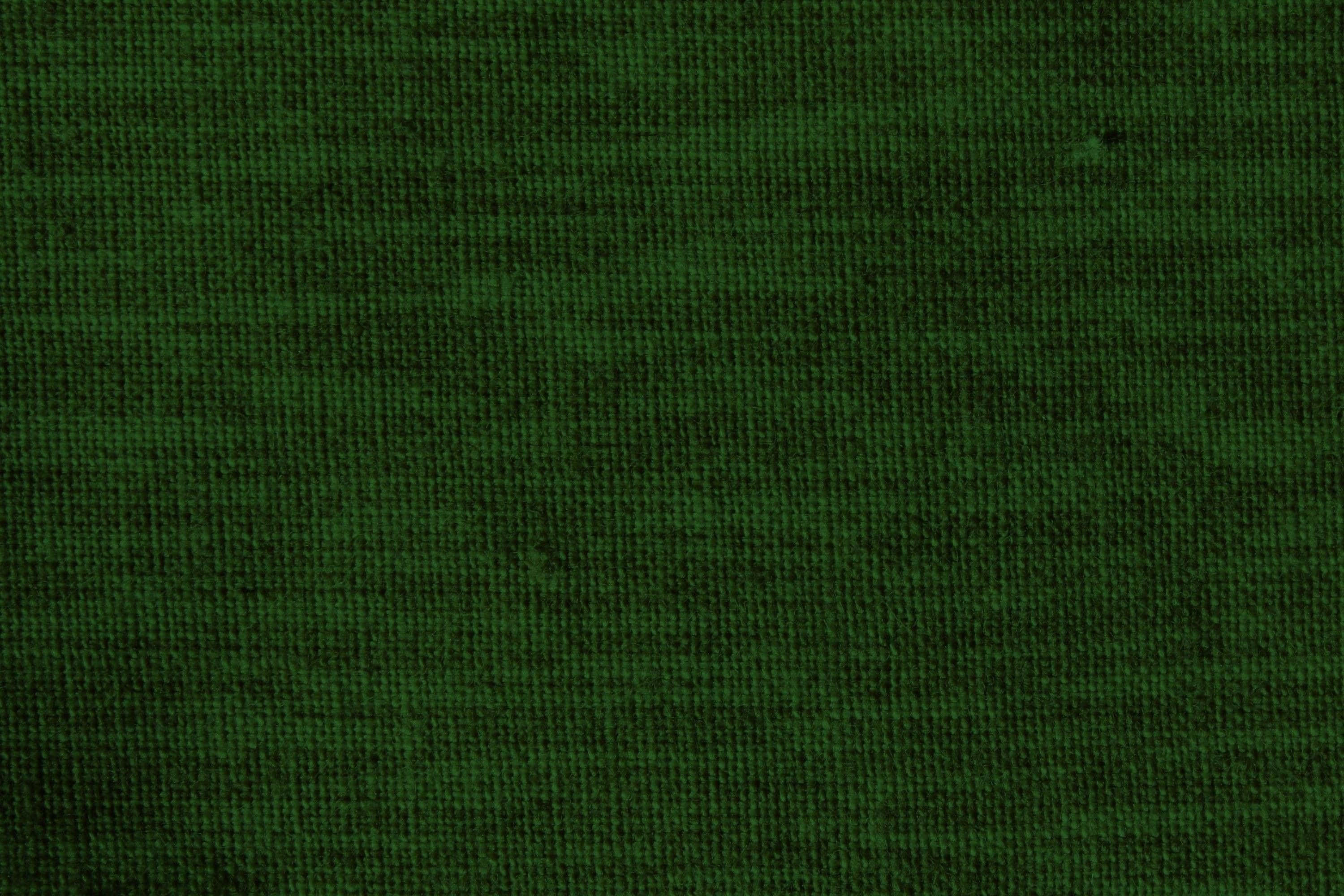 Dark Green Grunge 桌布 壁紙 — 深綠色紋理布料的特寫，帶有微妙的編織圖案和柔和光線。