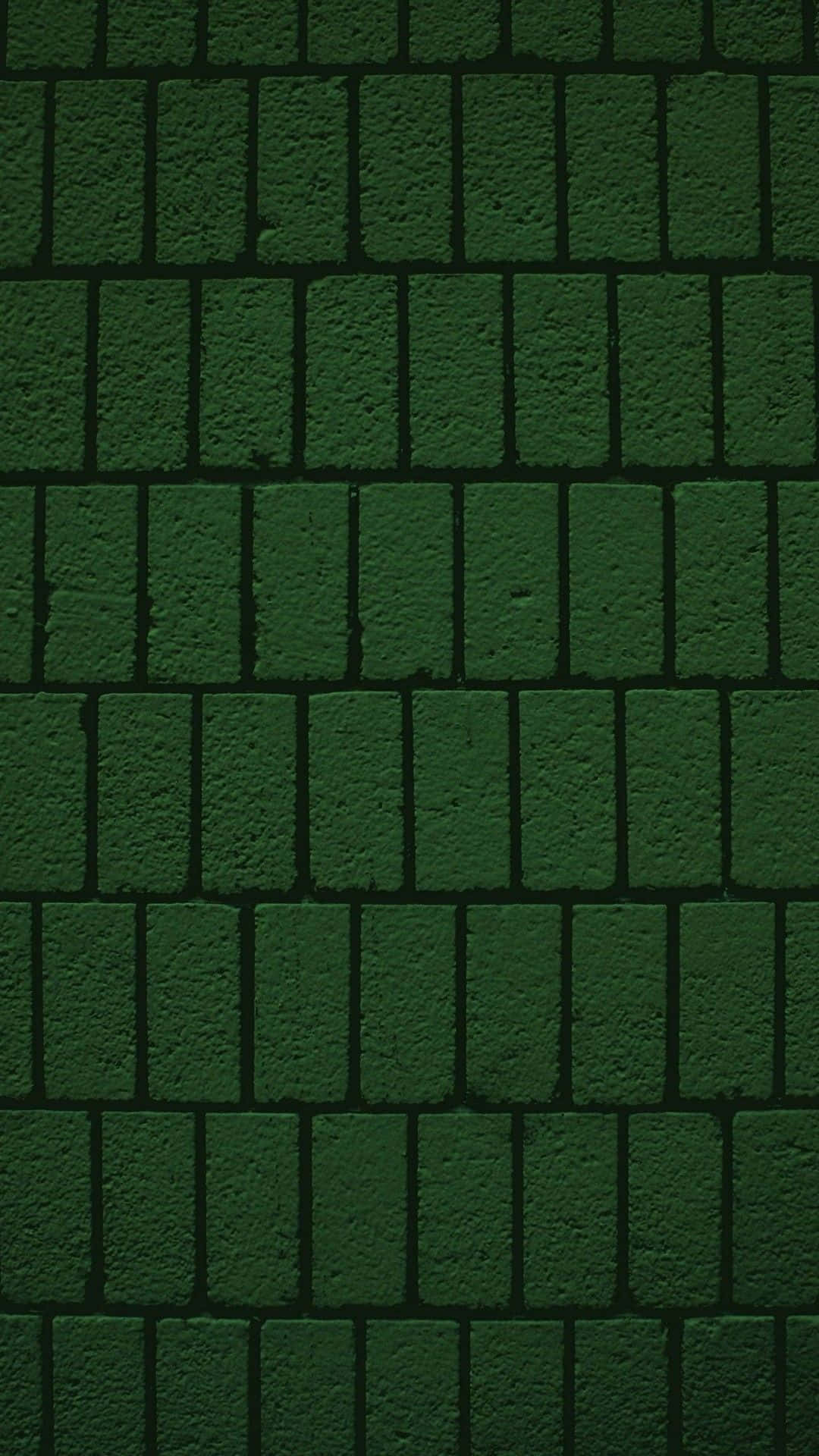 Dark Green Grunge 桌布 壁紙 — 深綠色紋理磚牆，帶有深邃陰影和粗糙表面細節。