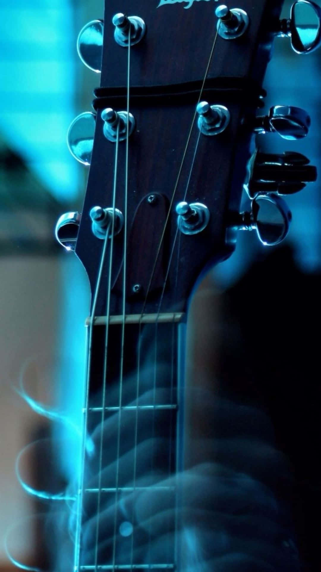 Guitar Aesthetic 桌布 壁紙 — 深色吉他頭特寫，帶有金屬調音栓和琴弦，在冷藍光下發光。