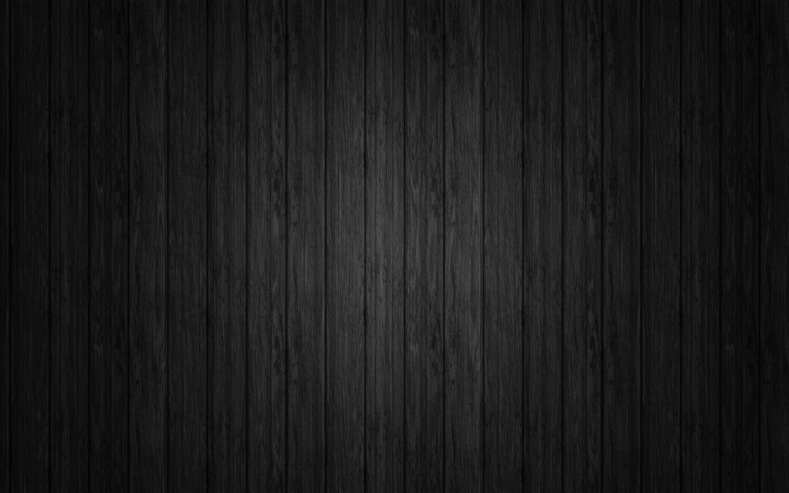Wood Texture 桌布 壁紙 — 深色垂直木板，帶有細微木紋紋理和柔和漸變燈光。
