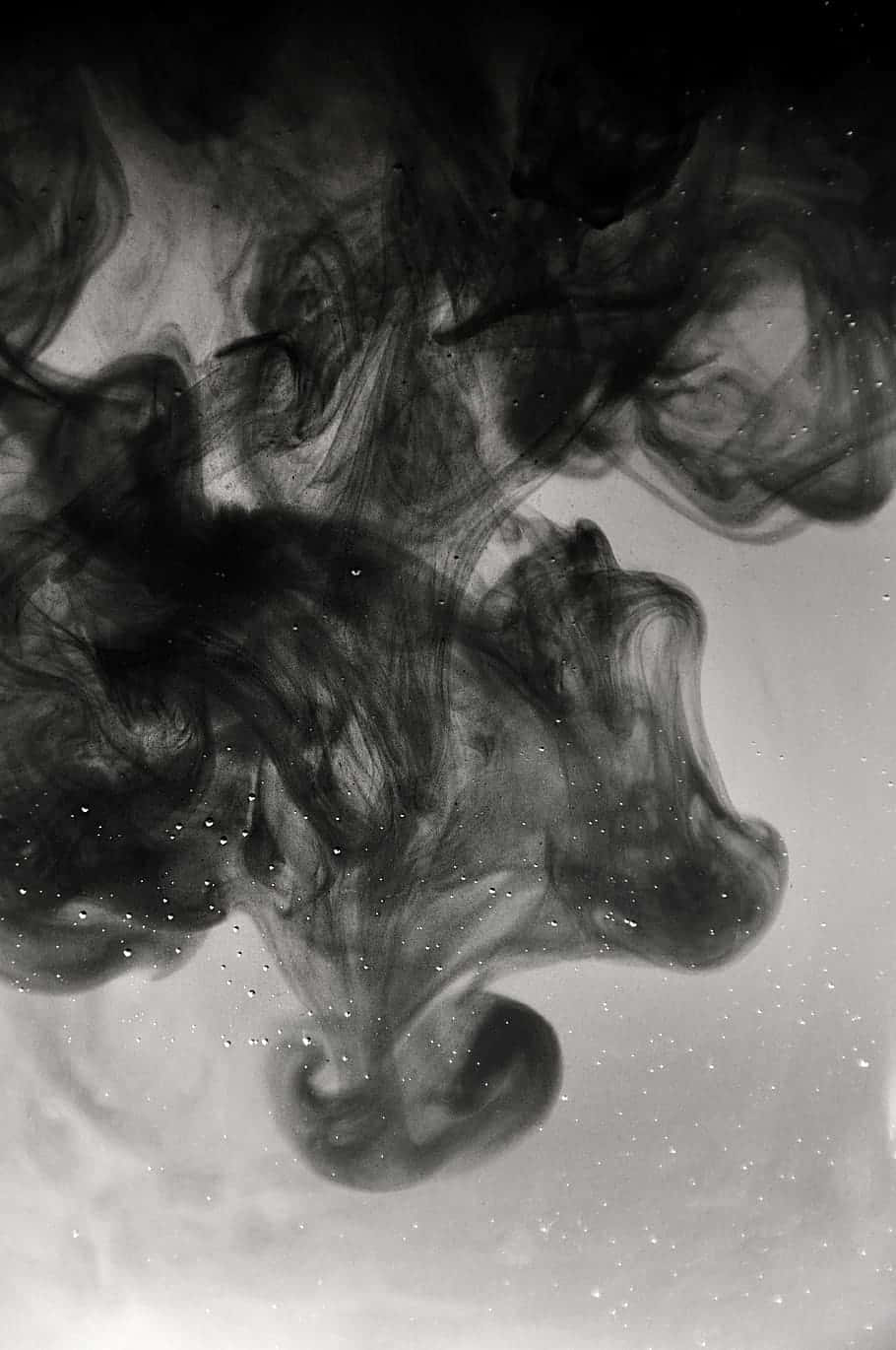 Black Smoke 桌布 壁紙 — 深色墨水在清水中優雅地旋轉，在淺色背景上創造出空靈的抽象形態。