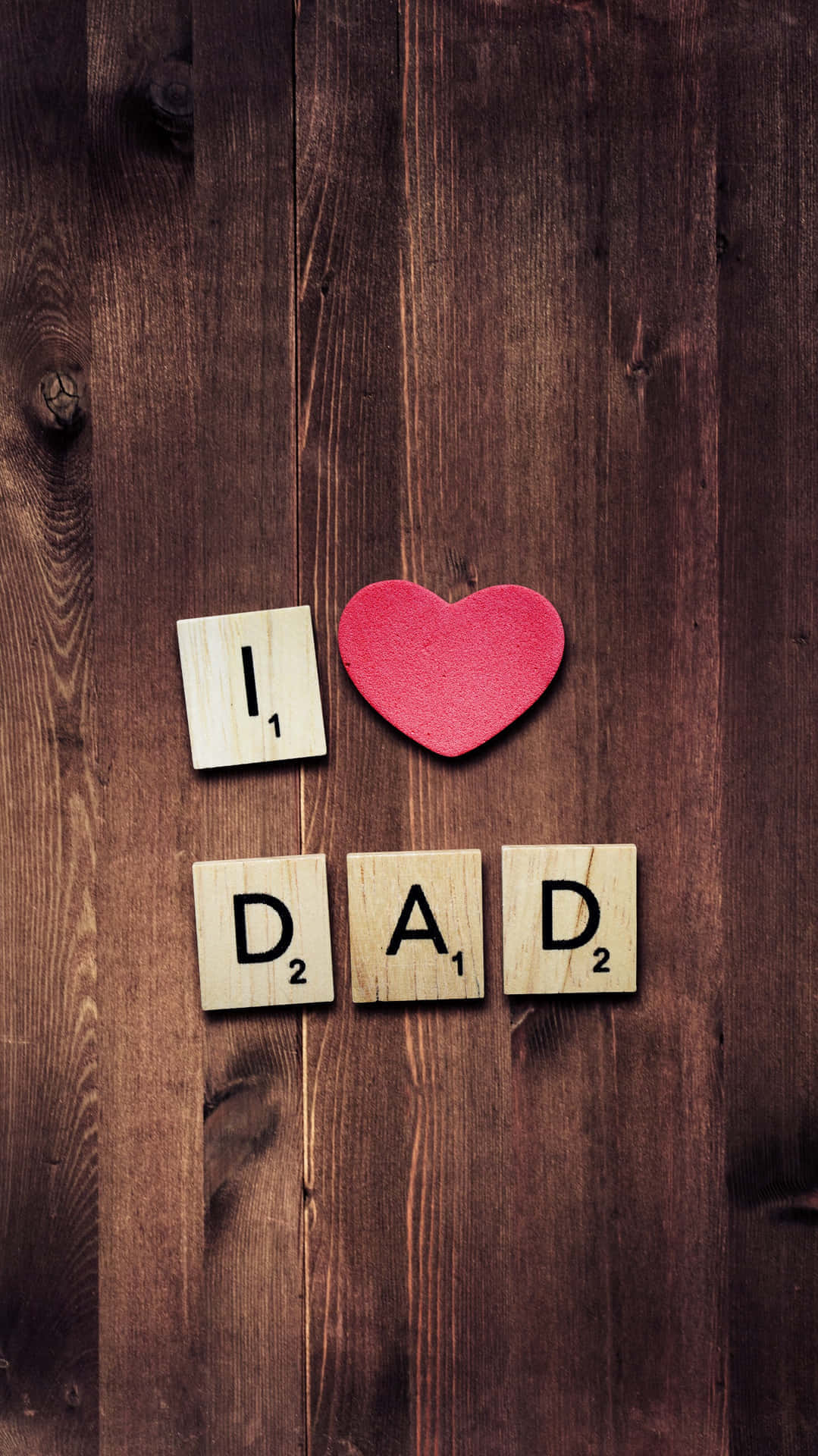 Dad 桌布 壁紙 — 深色木板上用 Scrabble 字母拼出 I LOVE DAD 並附有紅色心形。
