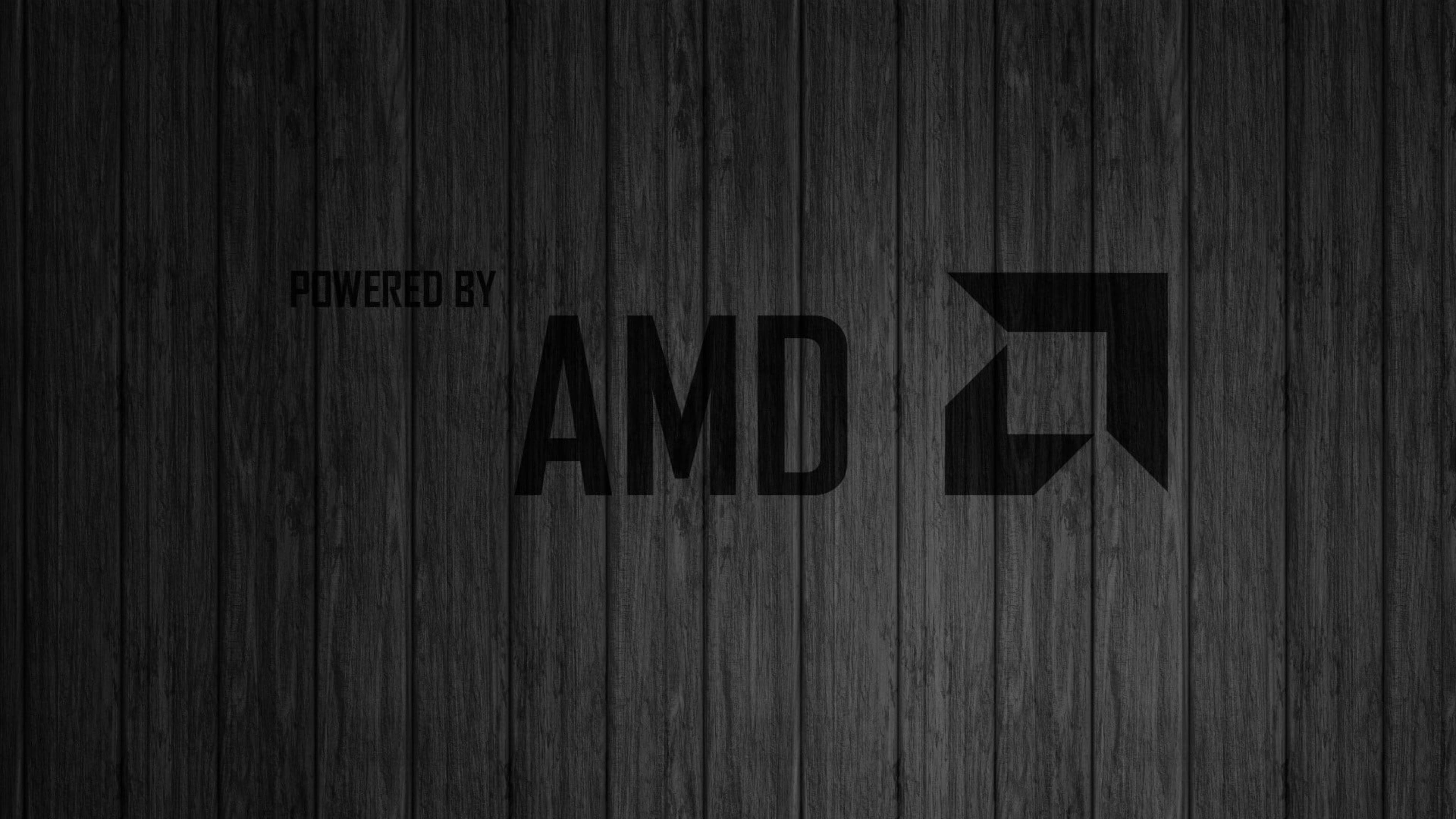 AMD 桌布 壁紙 — 深色木板作為背景，襯托出大膽的黑色AMD標誌和「powered by」文字。