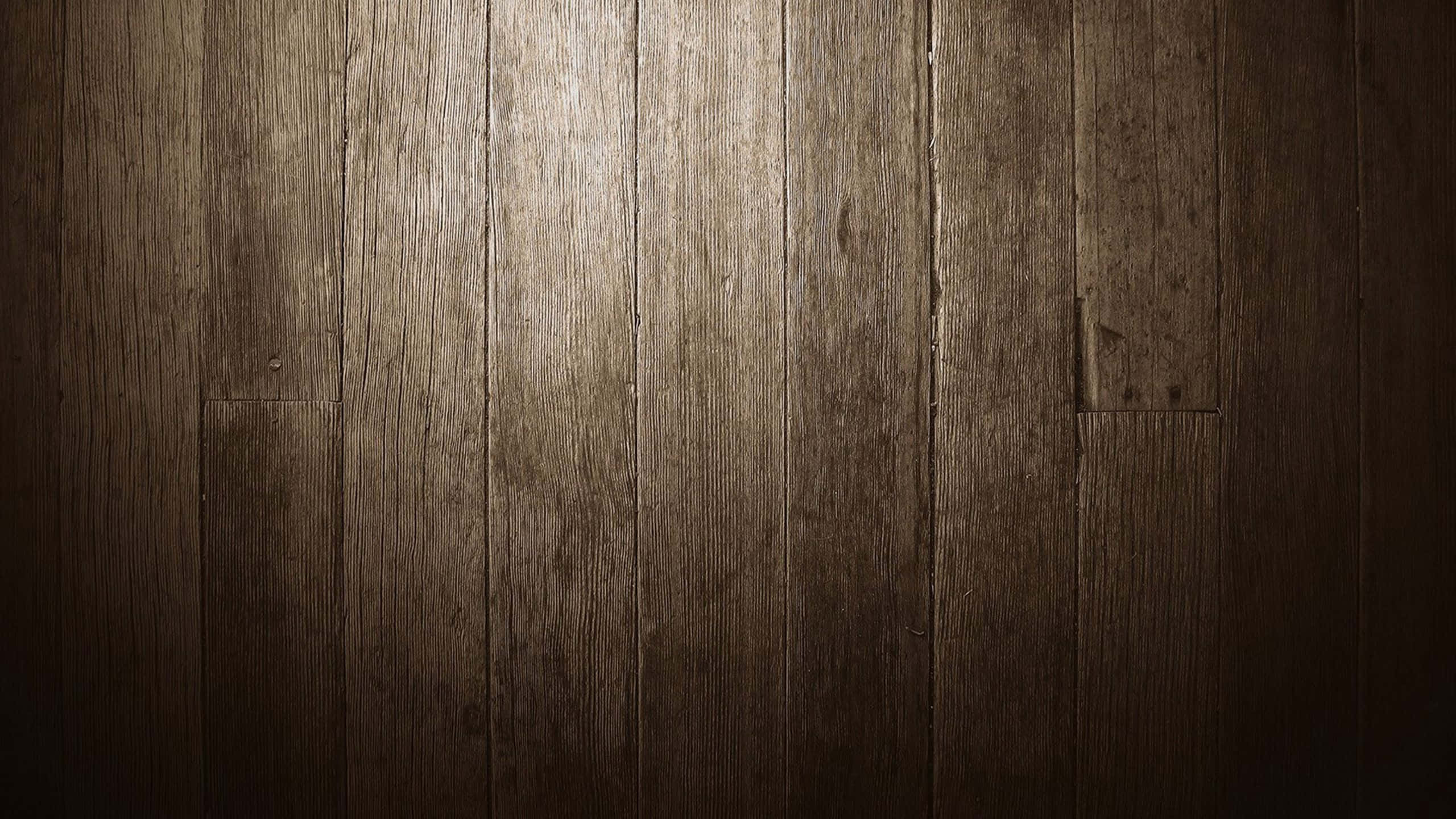 Wood Grain 桌布 壁紙 — 深色木板的特寫，可見木紋和節疤，從上方以柔和溫暖的光線照亮。