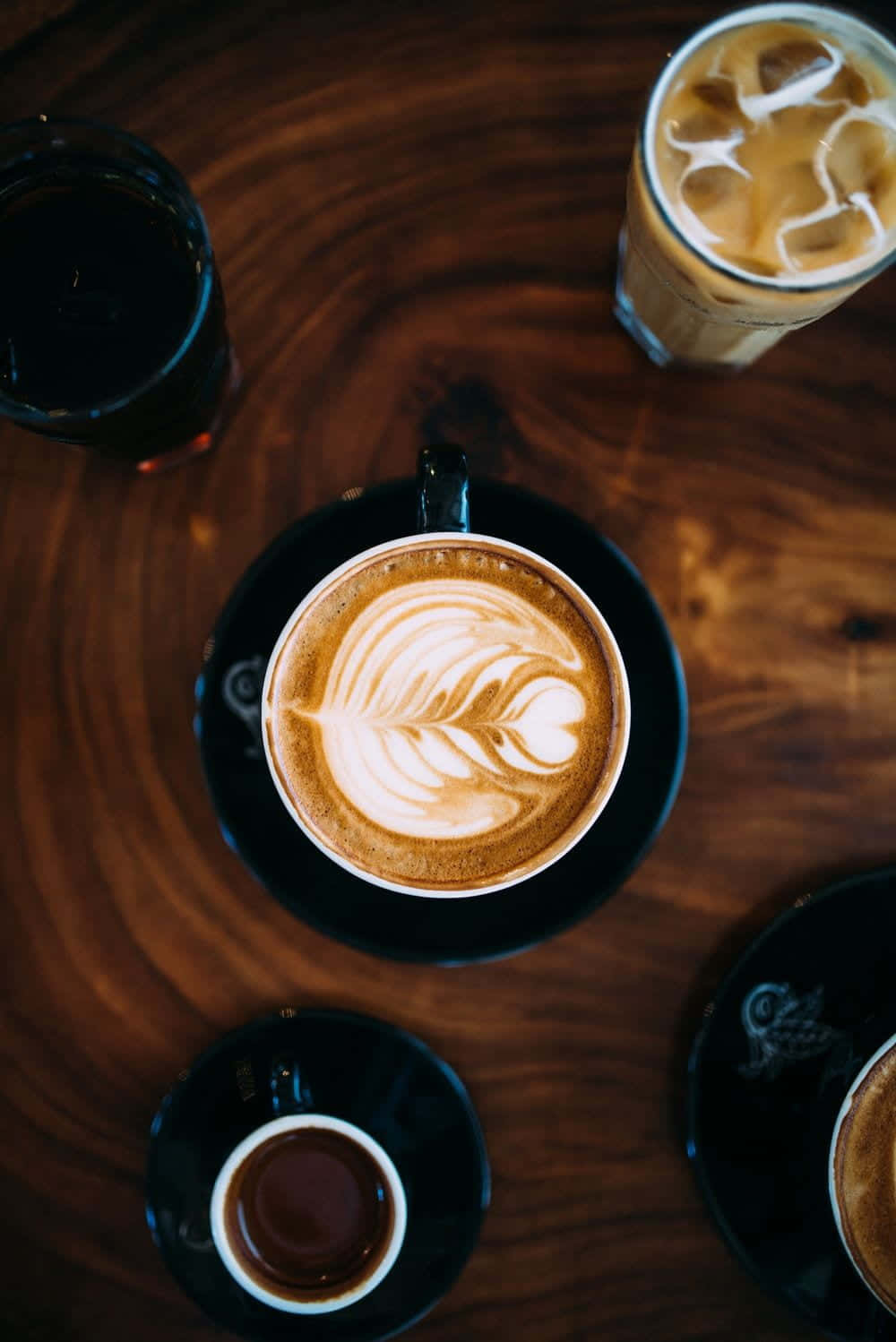 Iced Coffee 桌布 壁紙 — 深色木桌上帶有拉花藝術的咖啡飲品俯視圖。