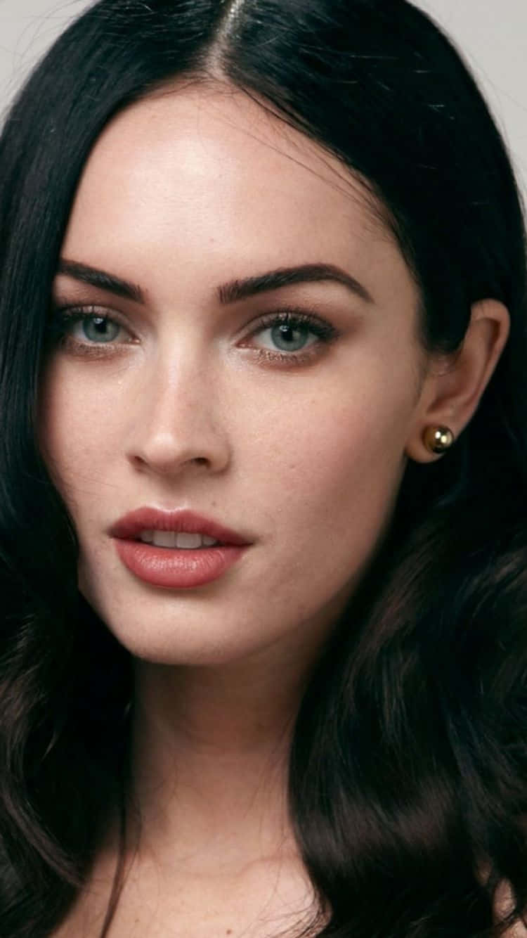 Celebrity 桌布 壁紙 — 深色波浪髮和引人注目的藍眼睛女性直視觀眾的特寫肖像。