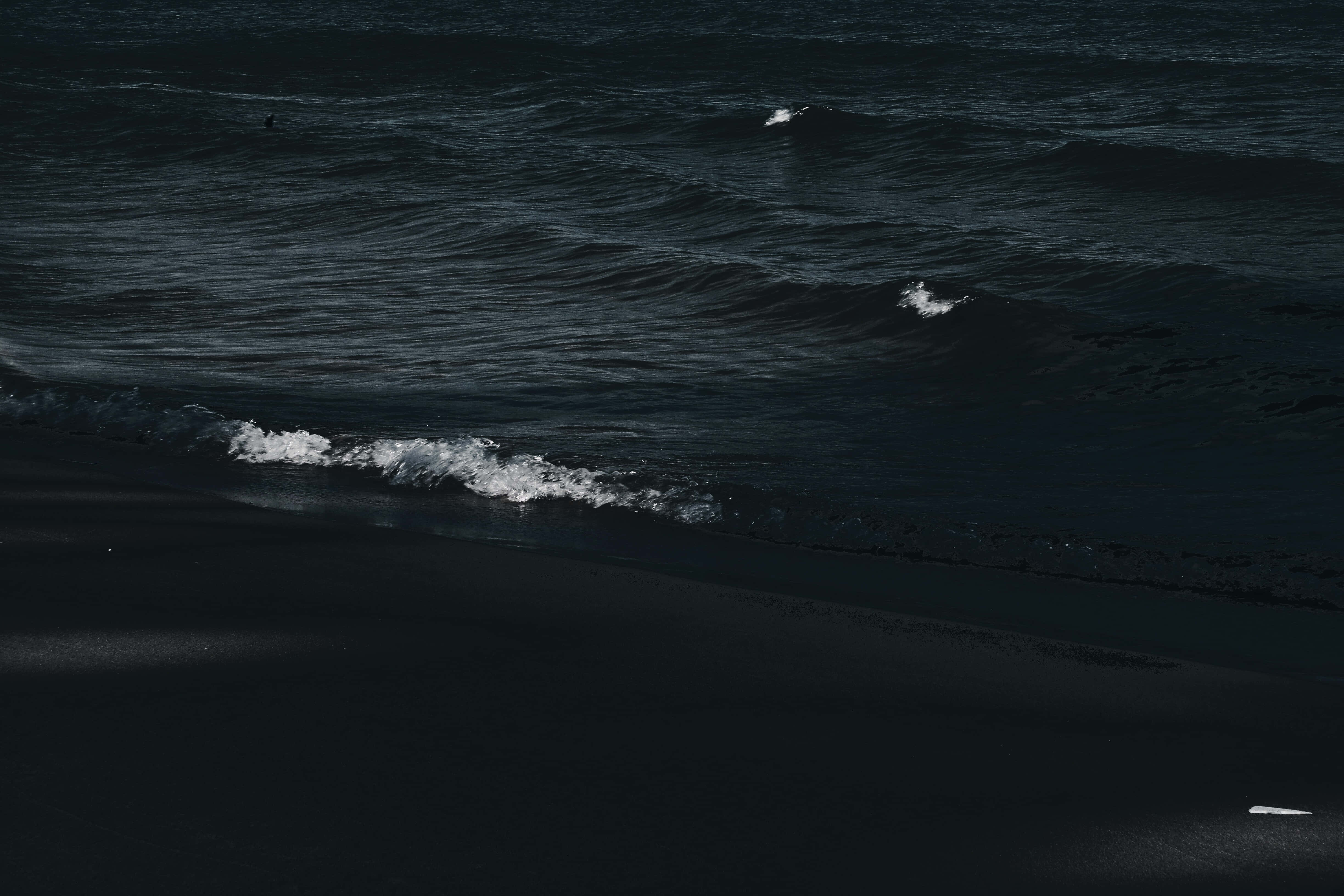 Dark Ocean 桌布 壁紙 — 深色海浪在陰鬱的暮色光照下衝上黑色火山海灘。