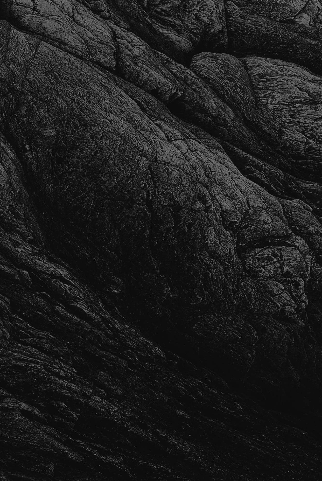 Stone Wall 桌布 壁紙 — 深色紋理岩層的特寫，帶有深邃陰影和崎嶇輪廓。