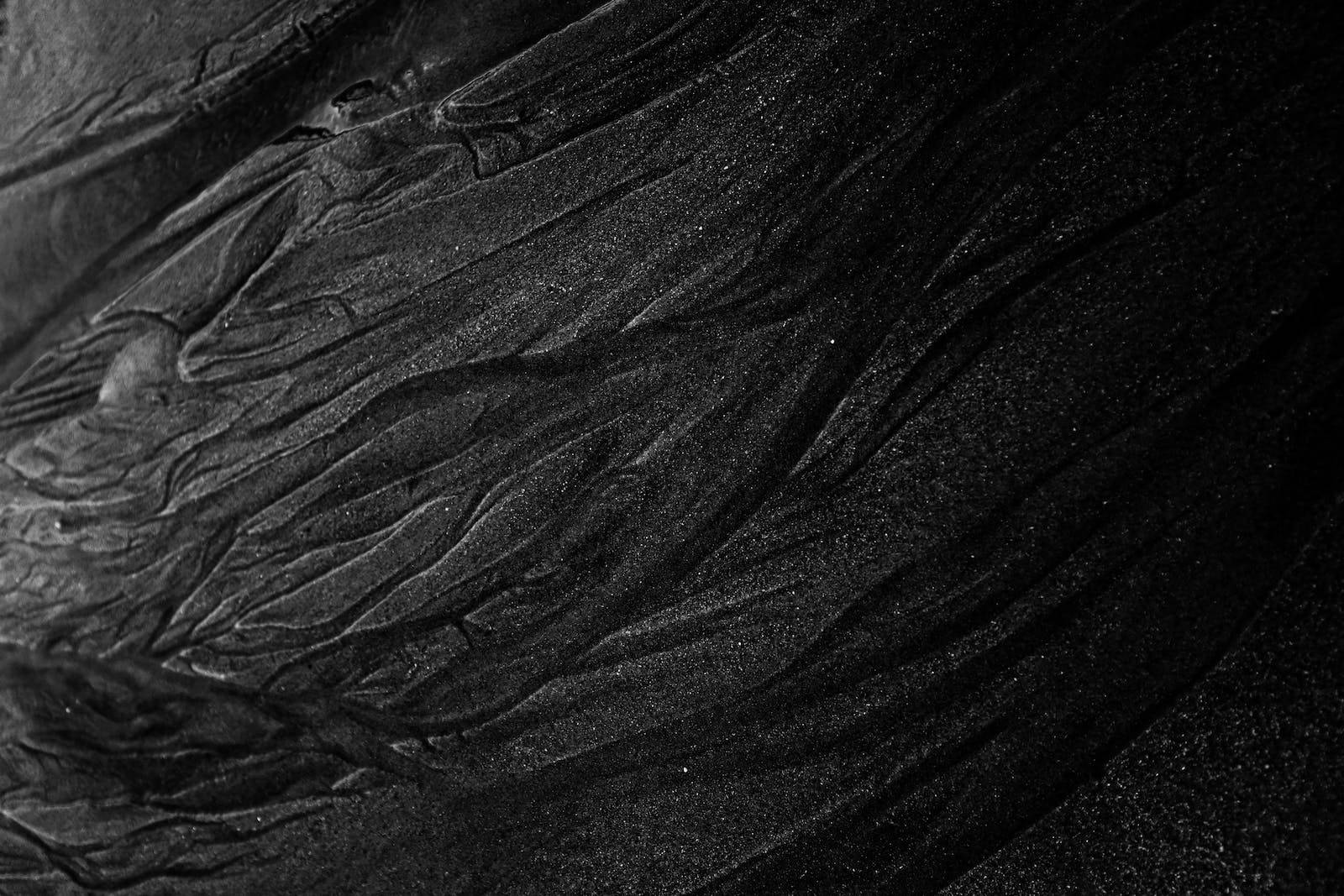 simple dark aesthetic 桌布 壁紙 — 深色紋理布料的特寫，帶有複雜的褶皺和微妙的閃爍亮點。