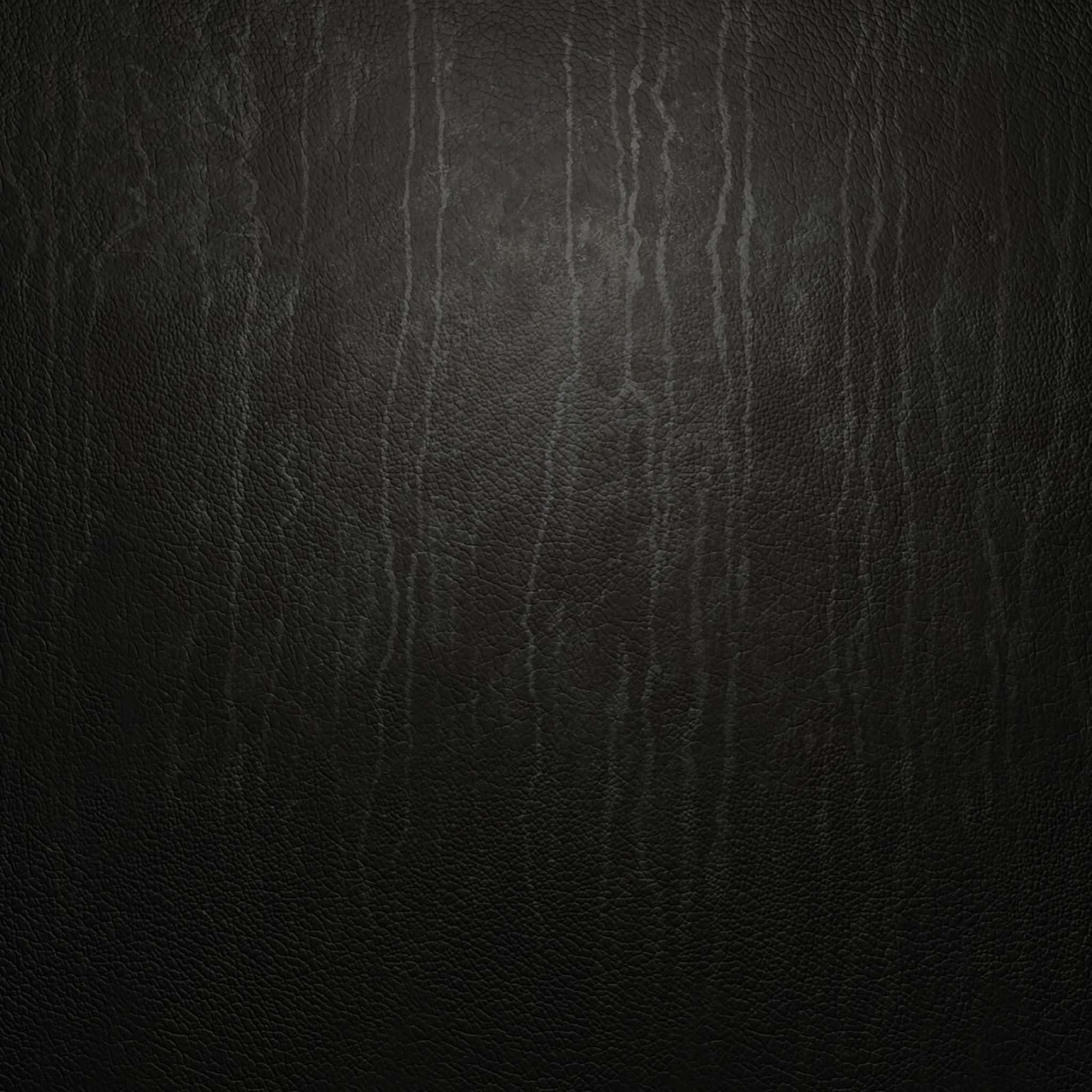 texture 桌布 壁紙 — 深色紋理皮革的特寫，在柔和光線下帶有微妙的垂直皺紋和紋理。