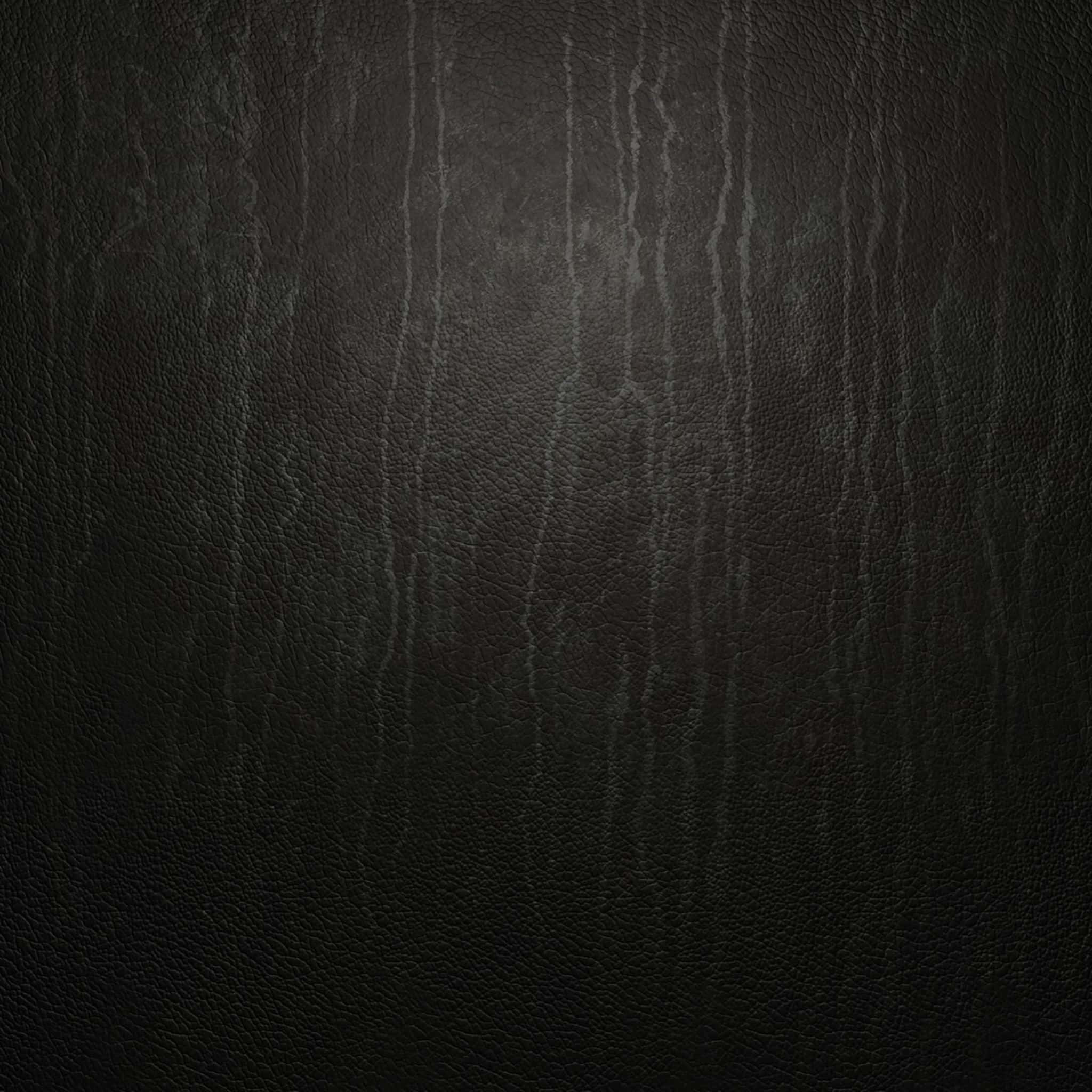 Black Leather 桌布 壁紙 — 深色紋理皮革的特寫，在柔和光線下帶有微妙的垂直皺紋和紋理。