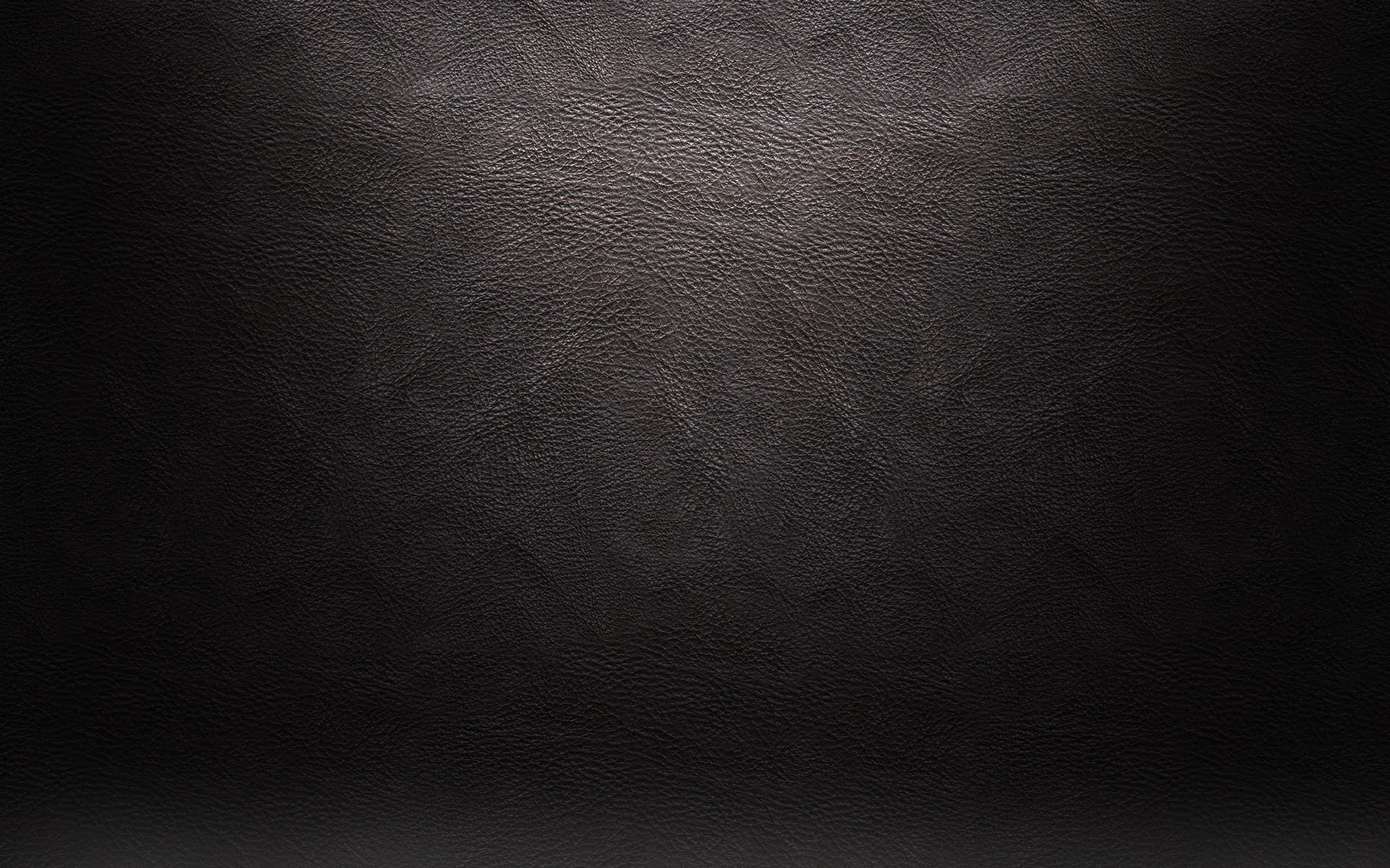 Leather 桌布 壁紙 — 深色紋理皮革的特寫，柔和光線突出其粒面表面。