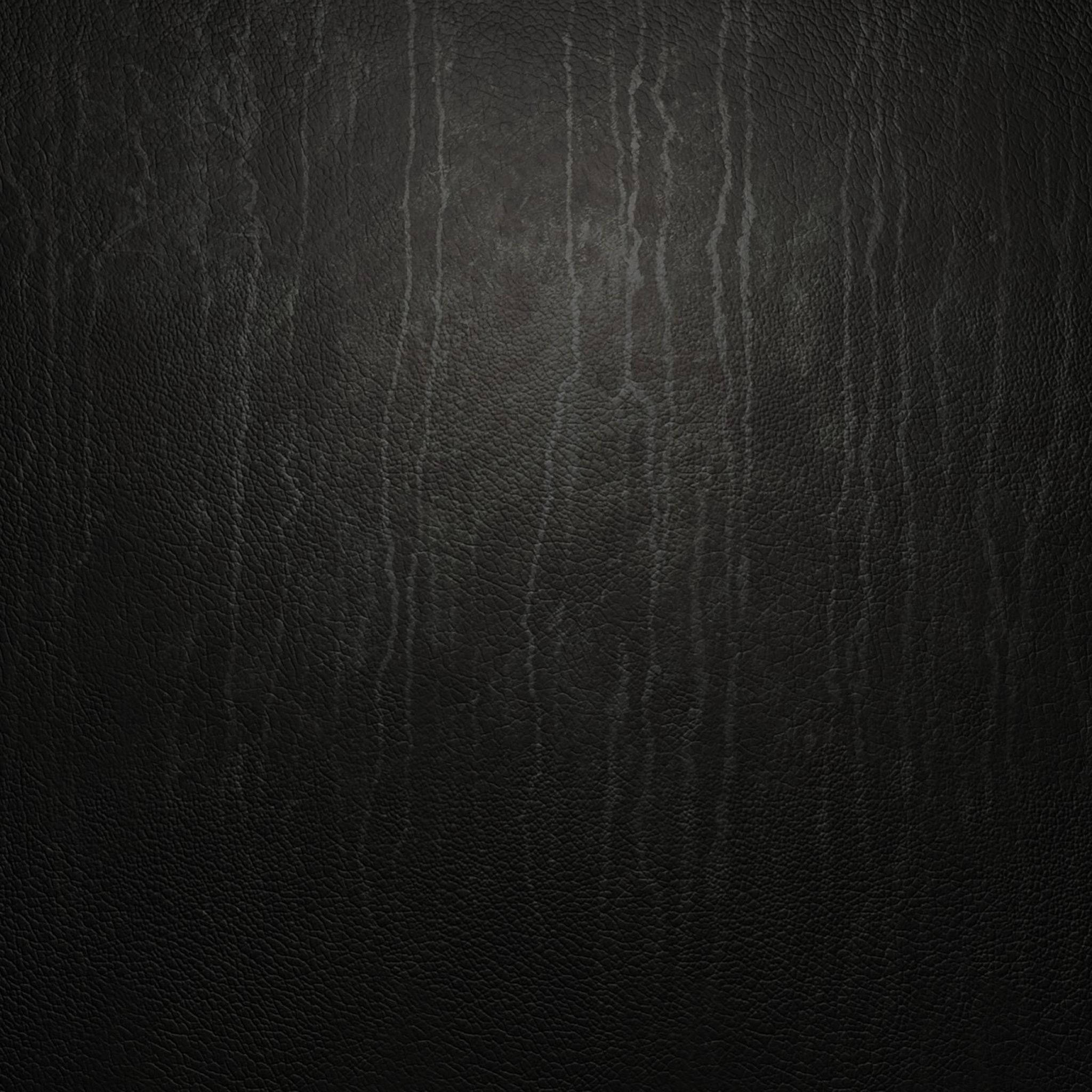 黑色 桌布 壁紙 — 深色紋理皮革表面的特寫，帶有微妙的垂直皺紋和微弱的光線反射。