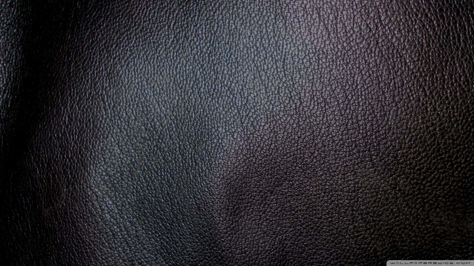 Black Leather 桌布 壁紙 — 深色紋理皮革表面的特寫，帶有微妙的漸變照明和自然紋理圖案。