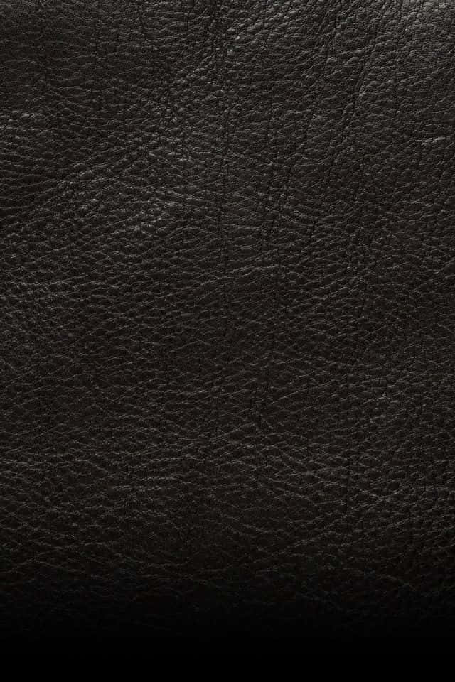 texture 桌布 壁紙 — 深色紋理皮革表面的特寫，帶有細微的紋理圖案和柔和的光線漸變。