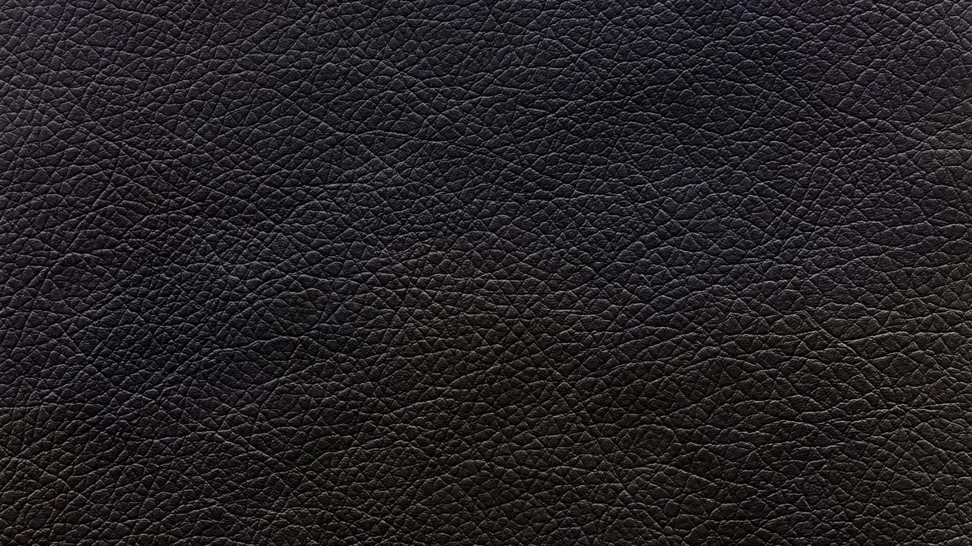 Leather 桌布 壁紙 — 深色紋理皮革表面的特寫，帶有細微的紋理圖案和柔和漸變照明。
