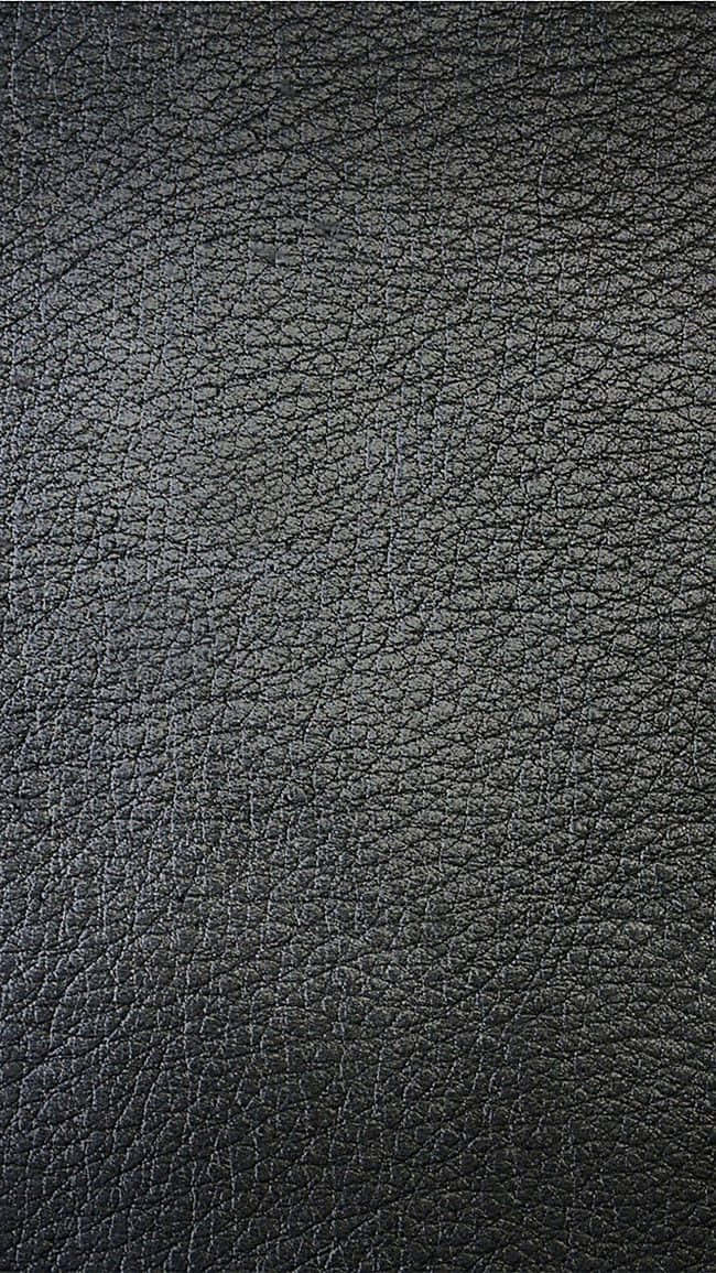 texture 桌布 壁紙 — 深色紋理皮革表面的特寫，帶有細微的紋理圖案和柔和的光線。