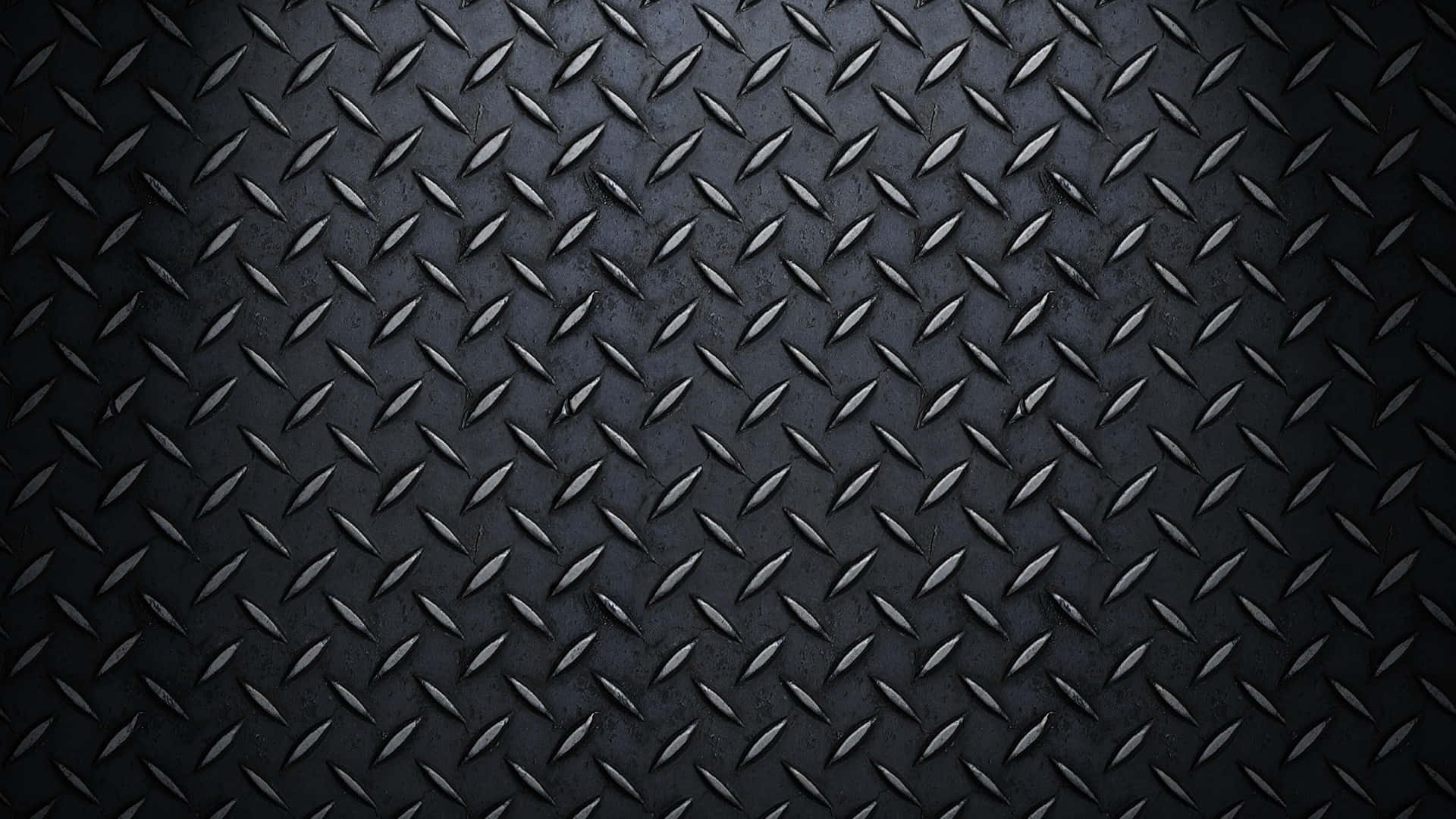 Material Design 桌布 壁紙 — 深色紋理菱形板金屬的特寫，具有銳利的幾何圖案和微妙的照明亮點。