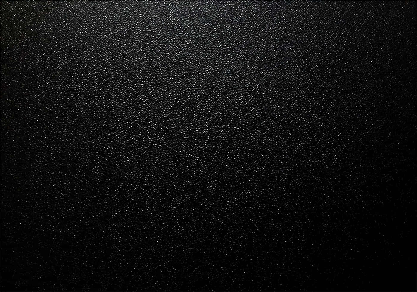 Dark Texture 桌布 壁紙 — 深色紋理表面的特寫，帶有細微斑點和從上到下的柔和漸變光暈。