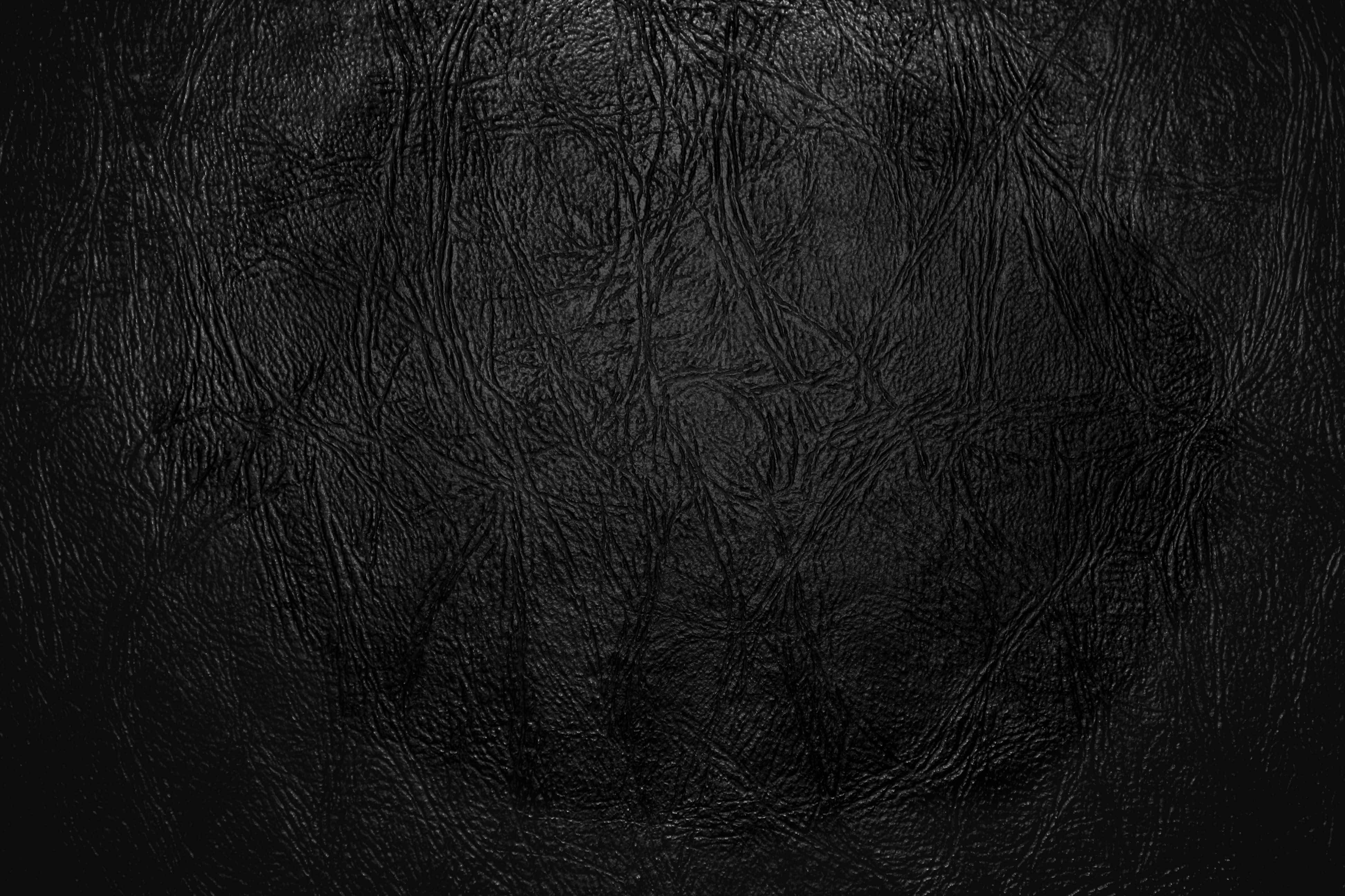 texture 桌布 壁紙 — 深色紋理黑色皮革表面的特寫，帶有細微的皺摺和自然紋理圖案。