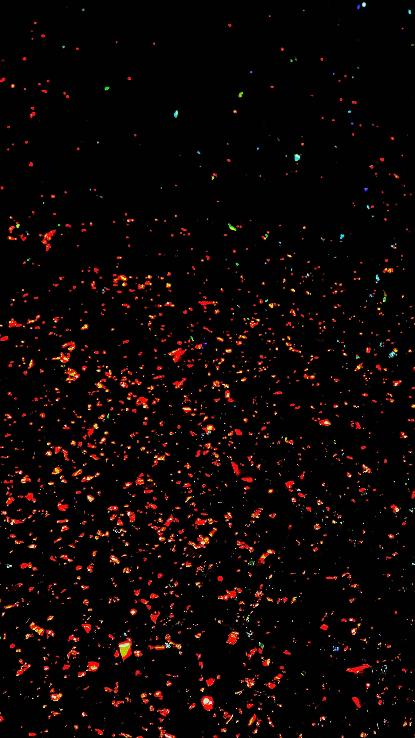 Sparkle Aesthetic 桌布 壁紙 — 深色背景上點綴著鮮豔的紅橙色和偶爾的藍綠色閃粉顆粒。