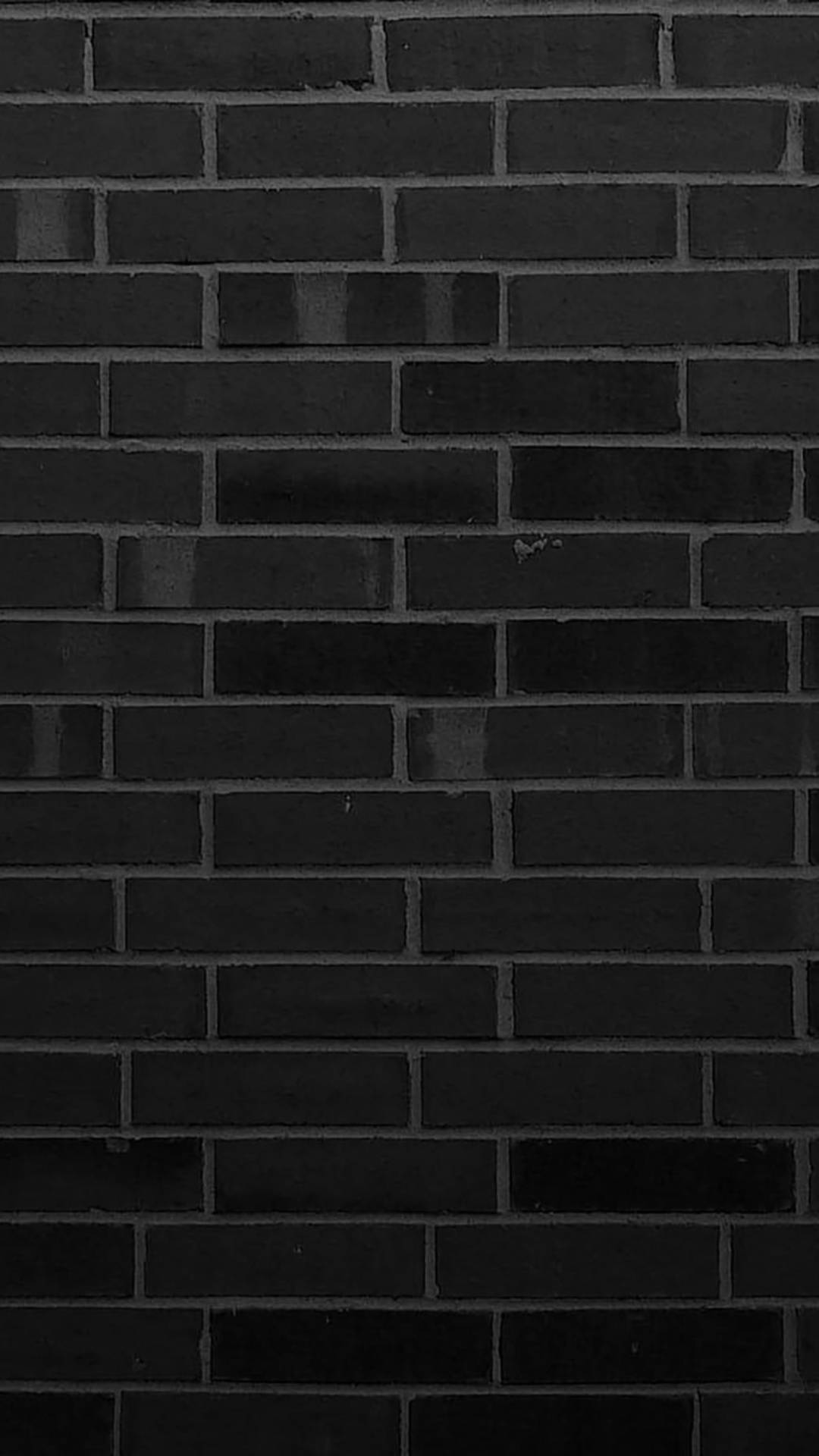 bricks 桌布 壁紙 — 深色霧面黑磚牆的特寫，帶有細微紋理和淺灰色砂漿線。