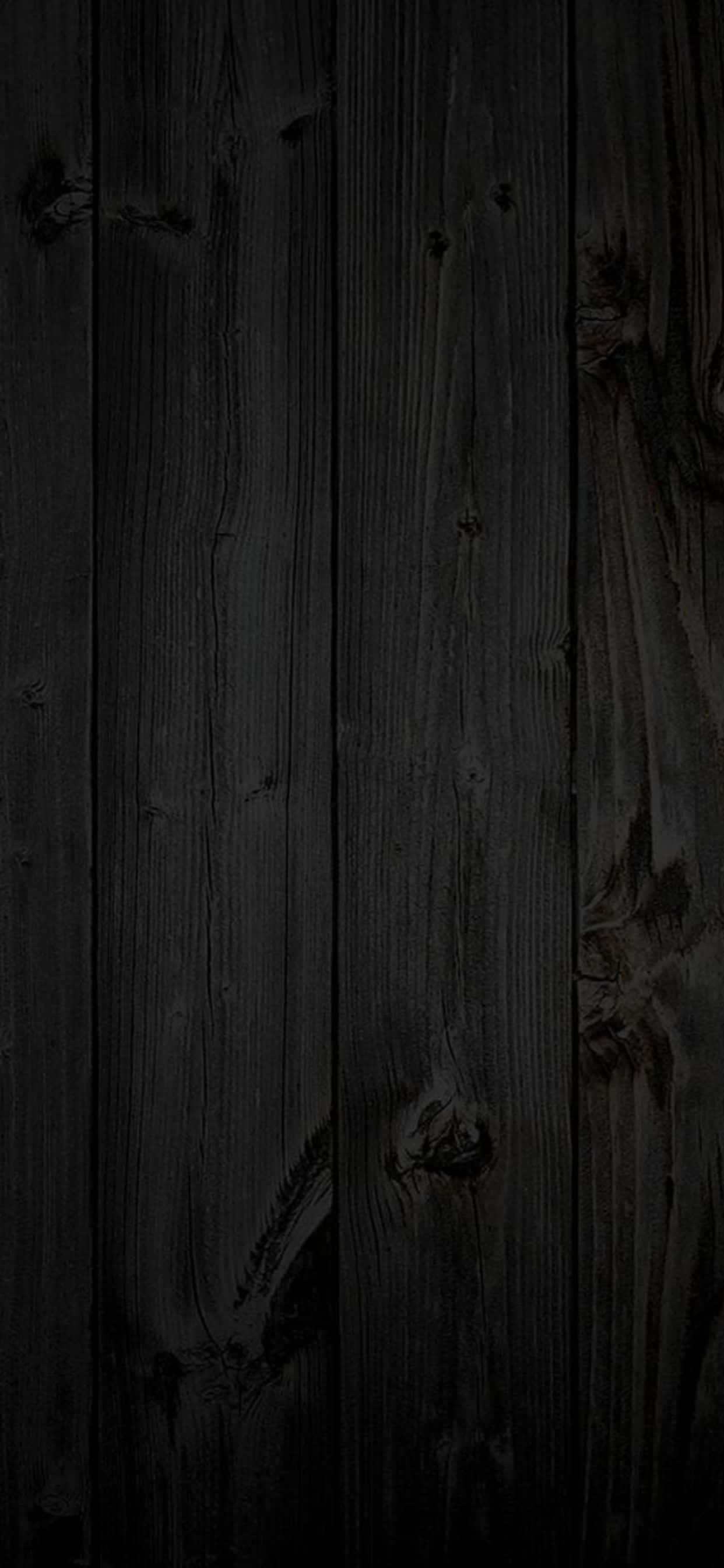 Black Wood 桌布 壁紙 — 深色風化木板，帶有可見的木紋、節疤和垂直接縫，處於深陰影中。