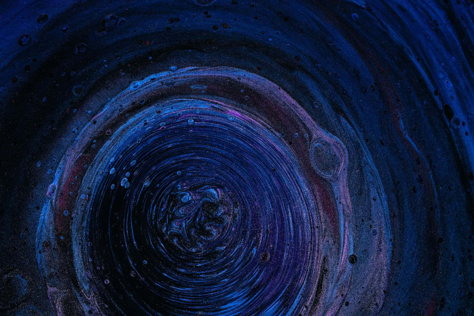 dark matter 桌布 壁紙 — 深藍色和紫色的迷人抽象漩渦，帶有同心圓環和斑點紋理。