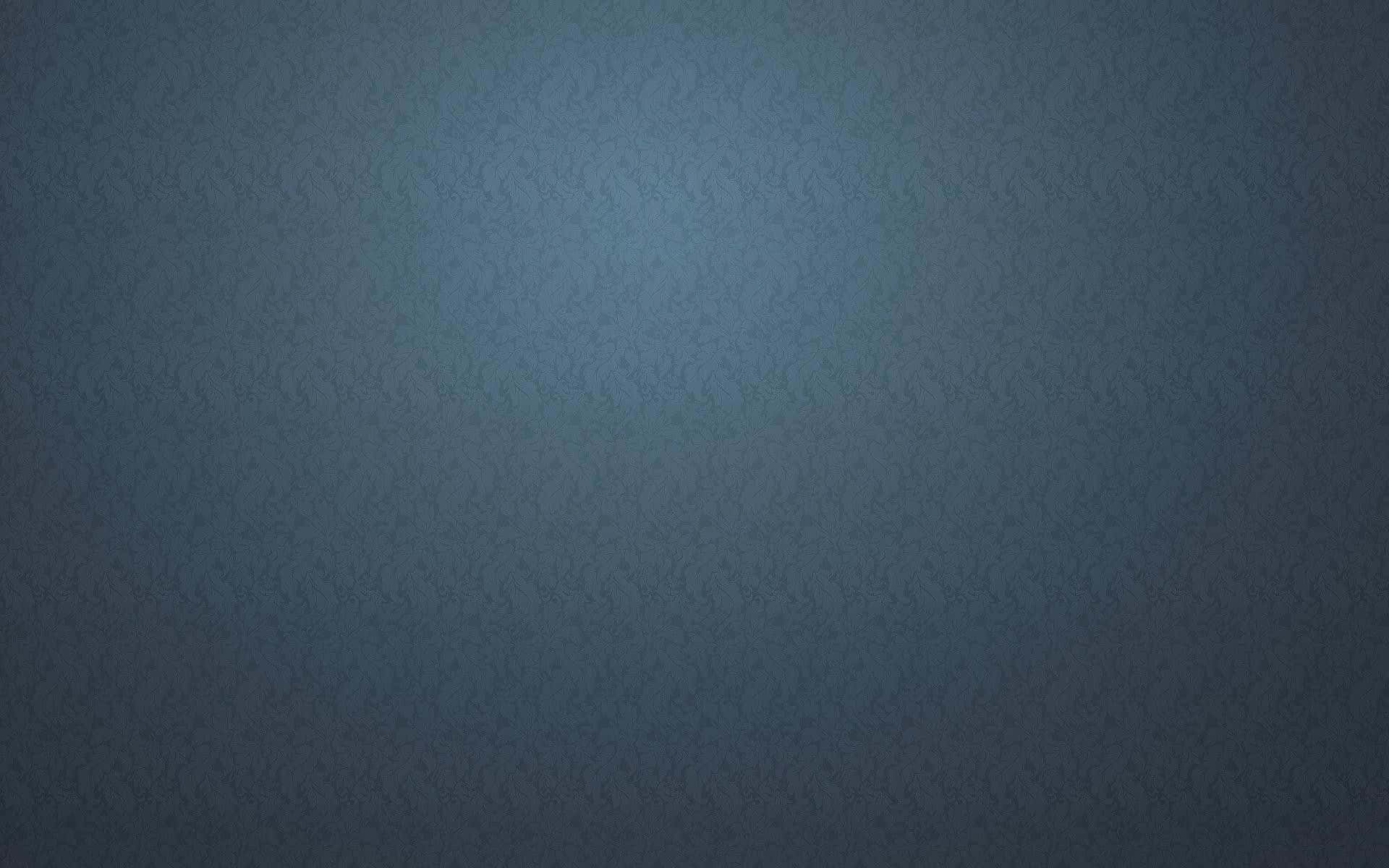 Blue And Gray 桌布 壁紙 — 深藍色壁紙的微妙漸變，帶有淡淡的紋理圖案和柔和的中間光芒。