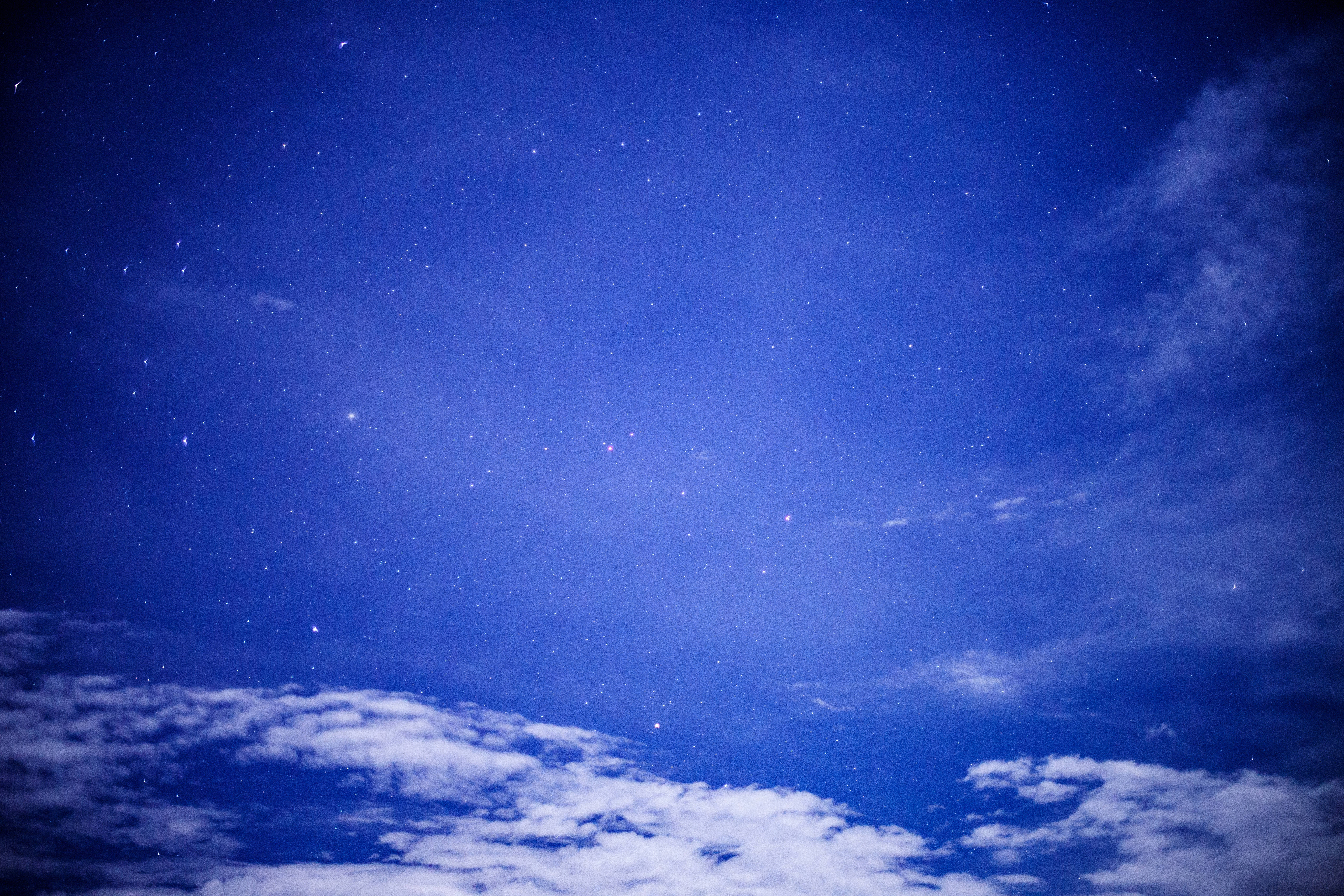 夜空 桌布 壁紙 — 深藍色夜空，佈滿閃爍星星，下方飄浮著柔軟白雲。