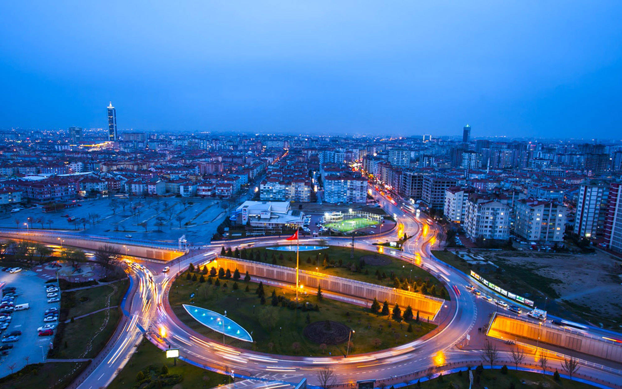 Konya 桌布 壁紙 — 深藍色天空下，暮色中城市的航拍視圖，有發光的道路和照亮的建築物。