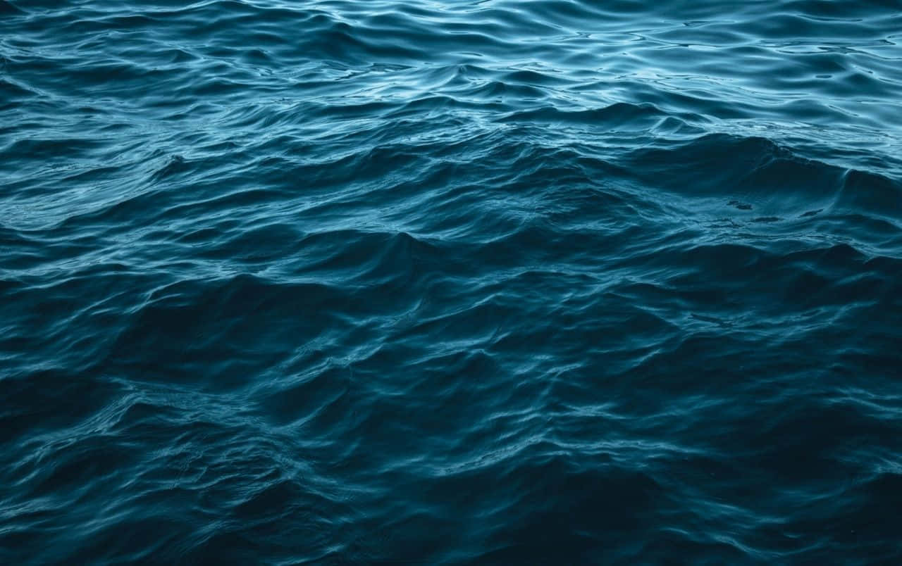 Ocean Waves 桌布 壁紙 — 深藍色海洋波浪在柔和環境光下帶有紋理運動的漣漪。