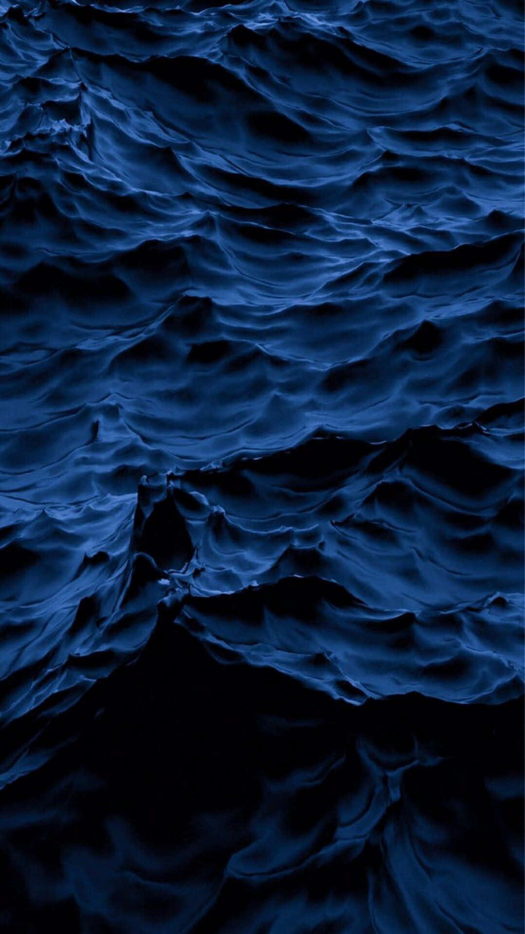 Azure Blue 桌布 壁紙 — 深藍色海洋波浪在陰鬱燈光下以戲劇性紋理泛起漣漪。
