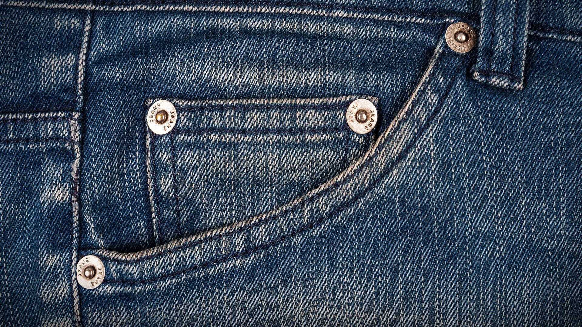 Denim 桌布 壁紙 — 深藍色牛仔褲後袋的特寫，顯示詳細的縫線和金屬鉚釘。