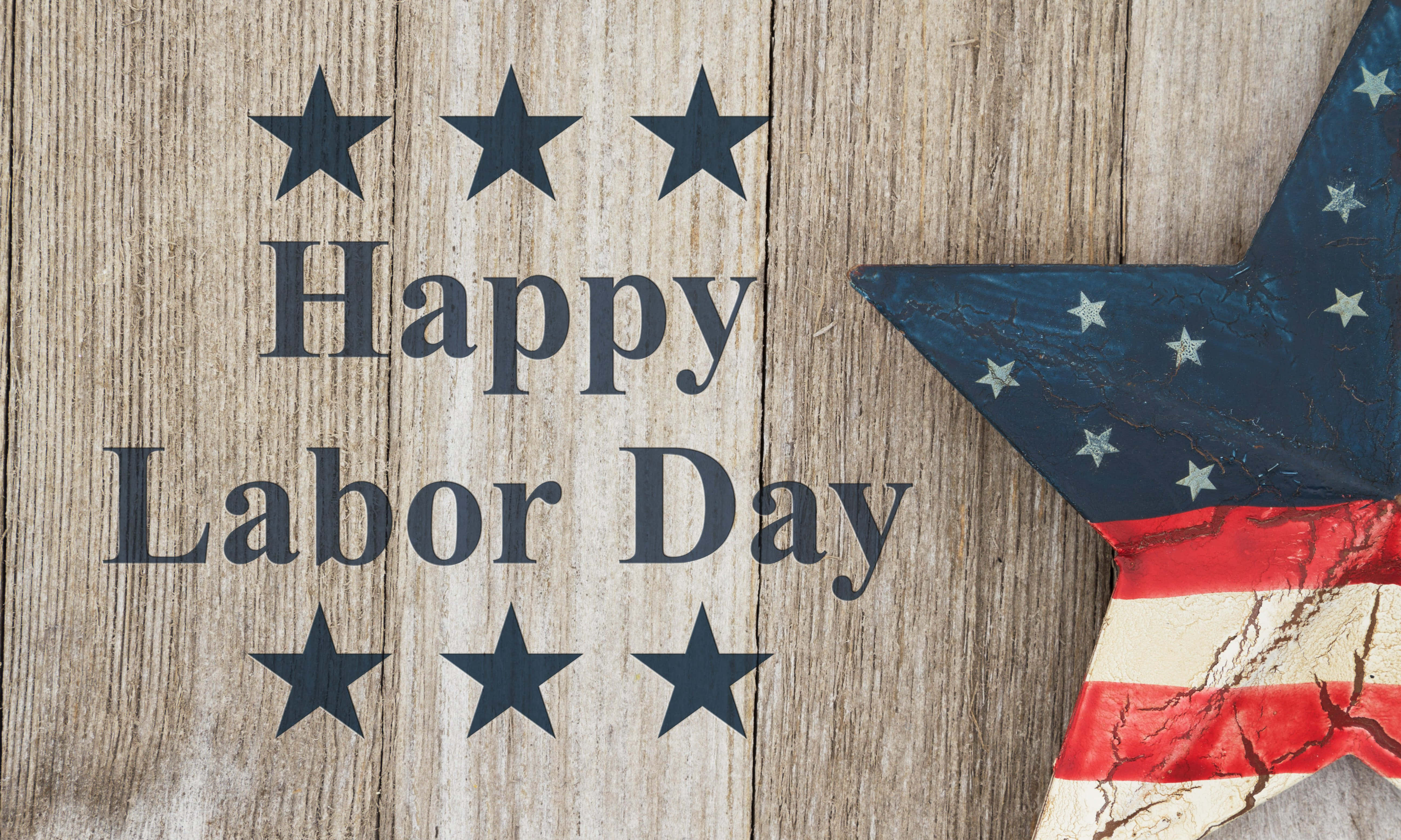 勞動節 桌布 壁紙 — 深藍色的「Happy Labor Day」文字在風化木上，並有紅白藍條紋的愛國星星。