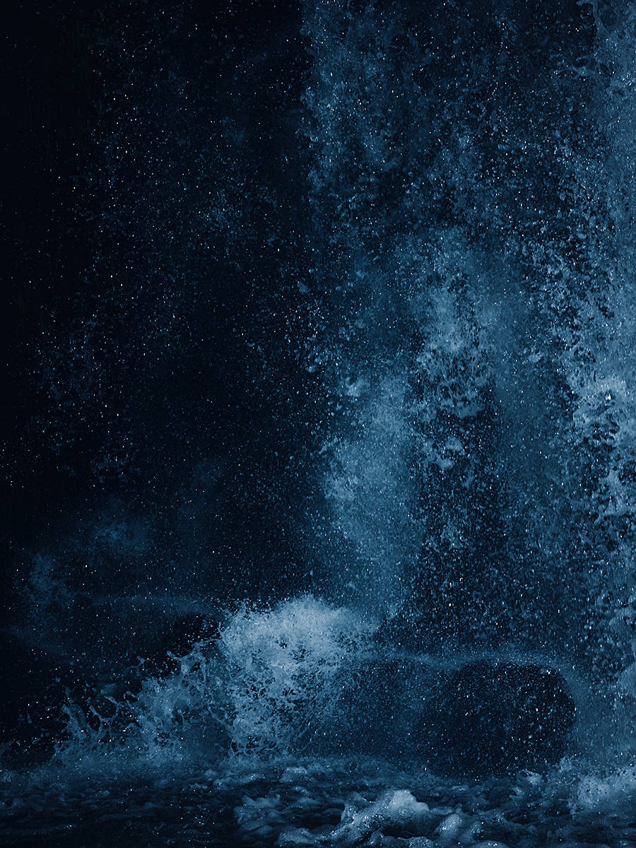 Falling Water 桌布 壁紙 — 深藍色的水在黑暗、霧氣瀰漫的環境中戲劇性地衝擊岩石。