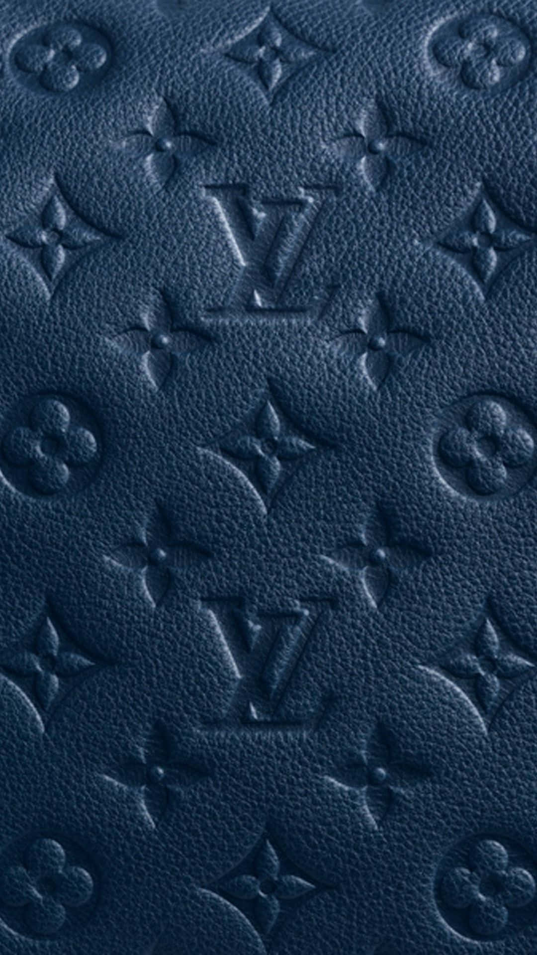 路易威登 桌布 壁紙 — 深藍色紋理皮革的特寫，帶有壓印的 Louis Vuitton 字母組合圖案。